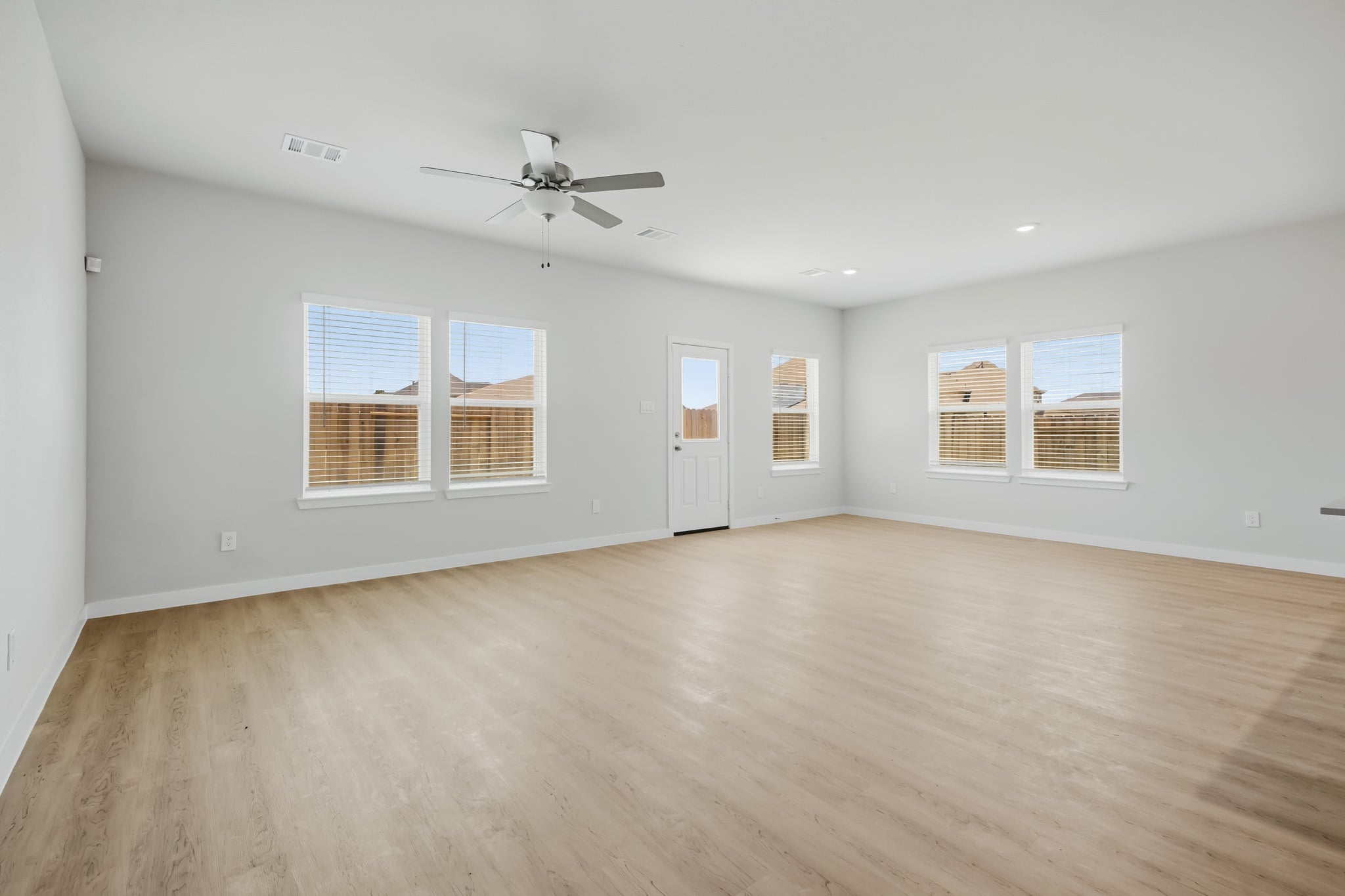 A room with a wood floor and a ceiling fan.