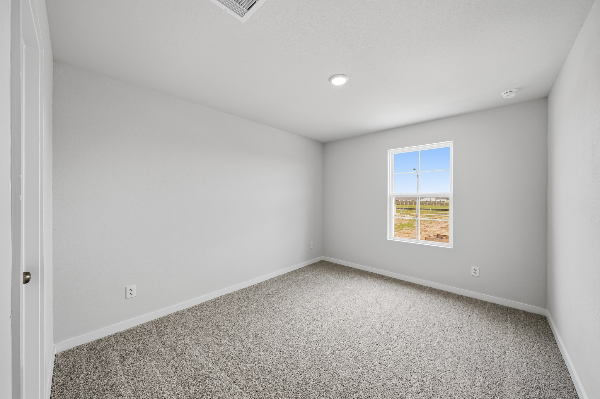 A room with a carpet and a window.