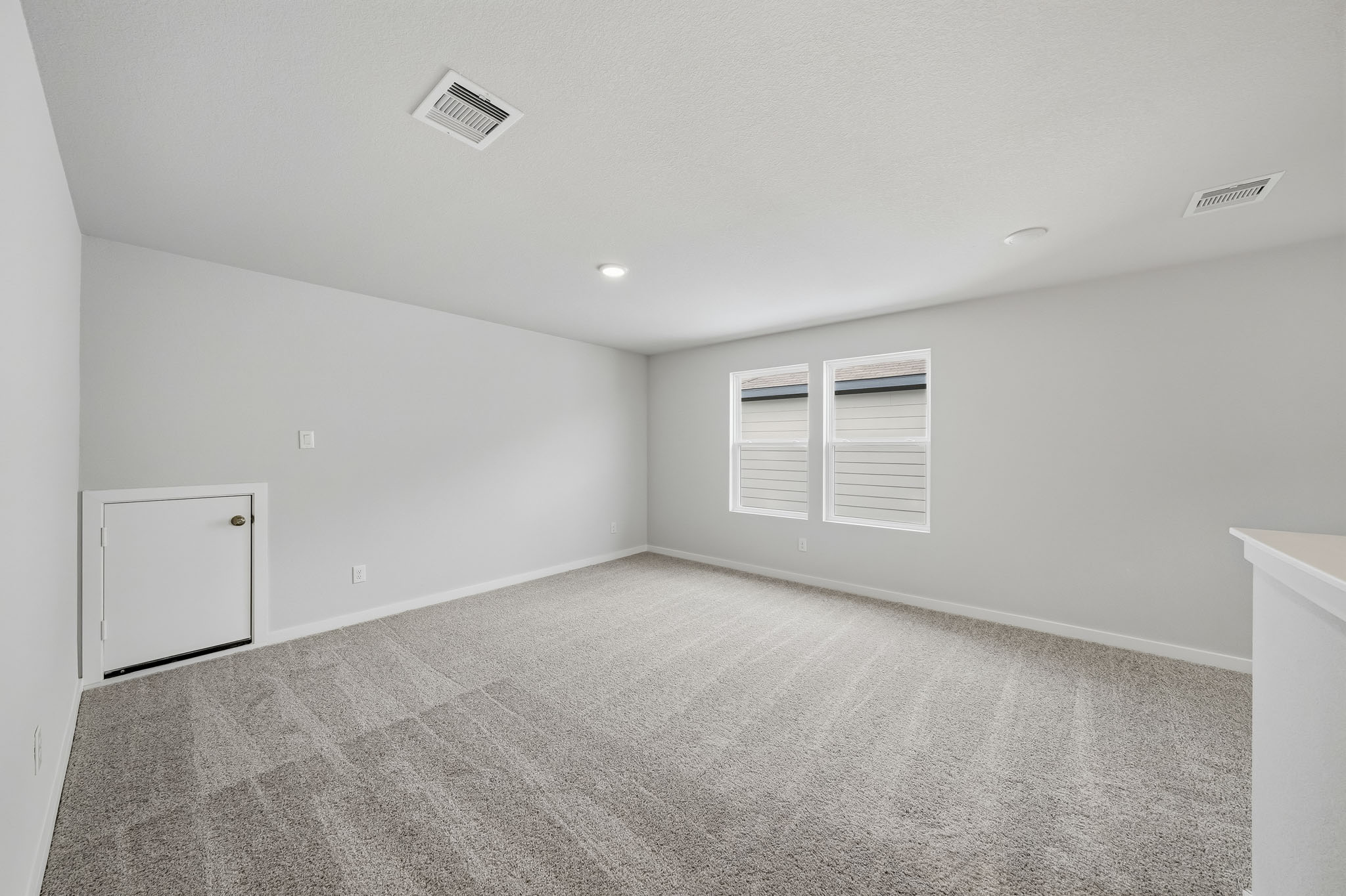 A room with a carpet and a white cabinet.