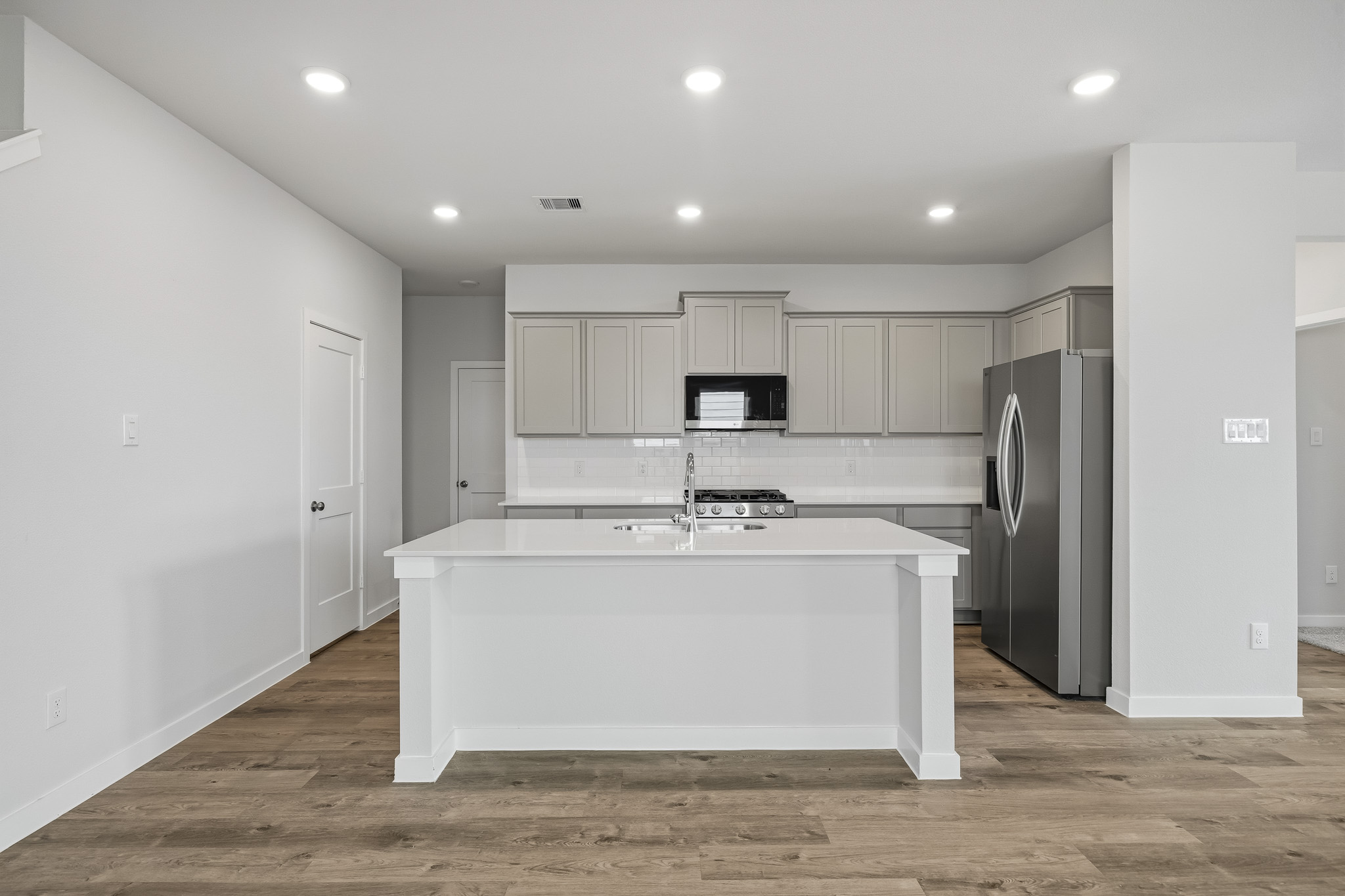 A kitchen with white cabinets.
