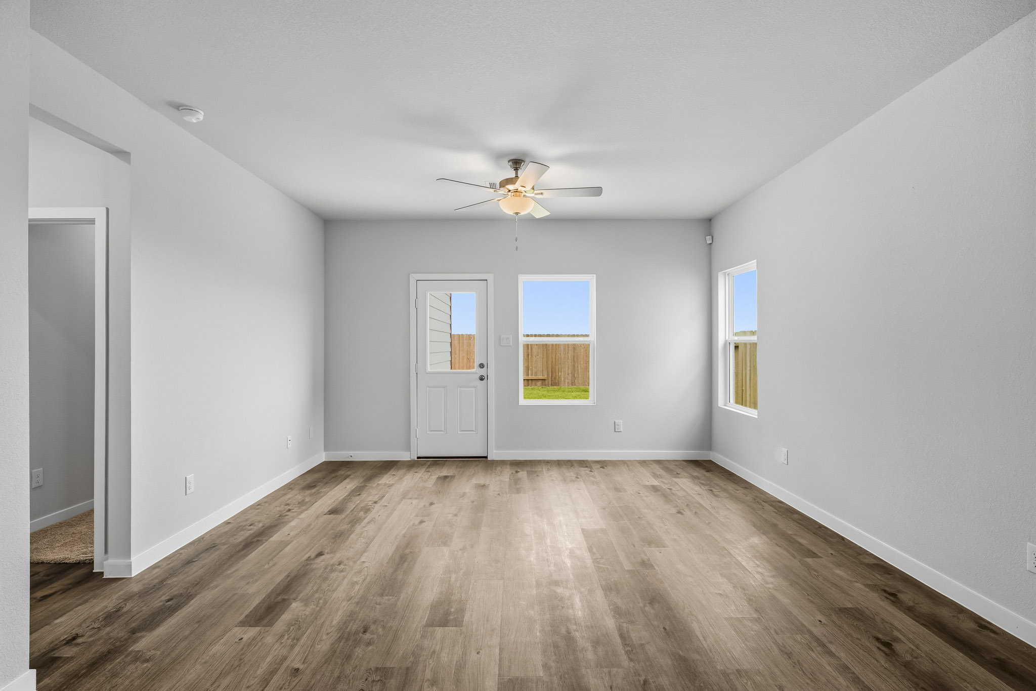 A room with a wood floor and a ceiling fan.