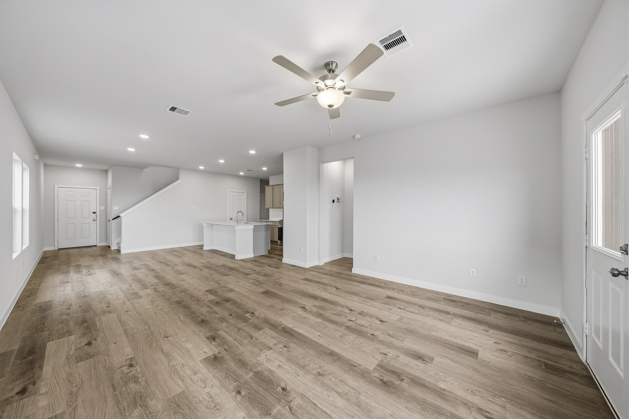 A room with a wood floor and a ceiling fan.