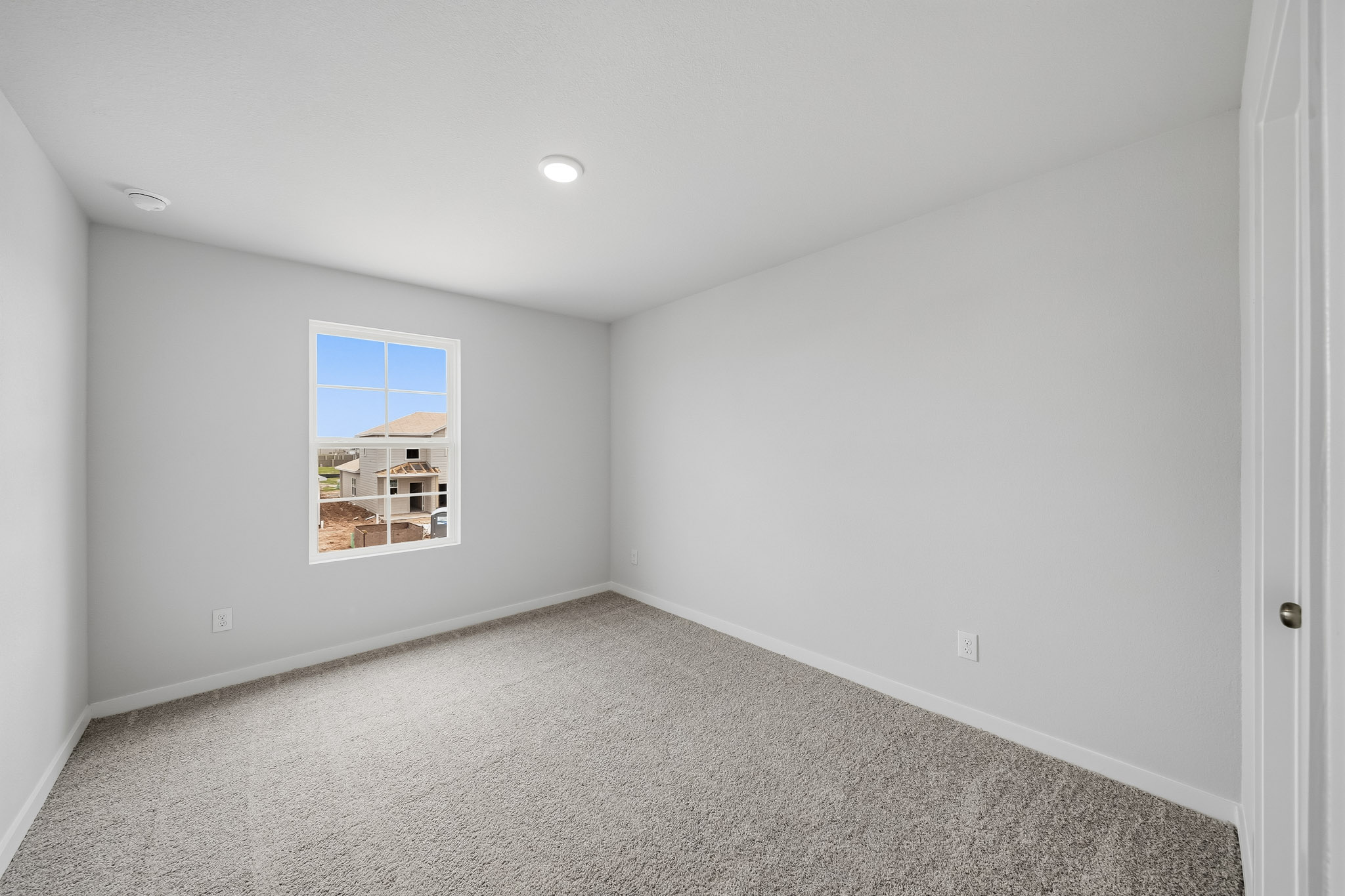 A room with a window and carpet.