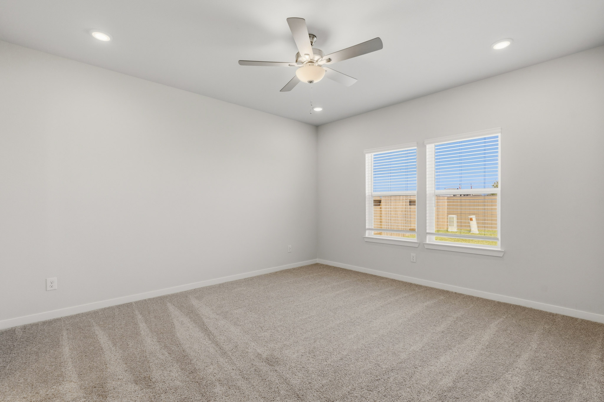 A room with a ceiling fan and a window.