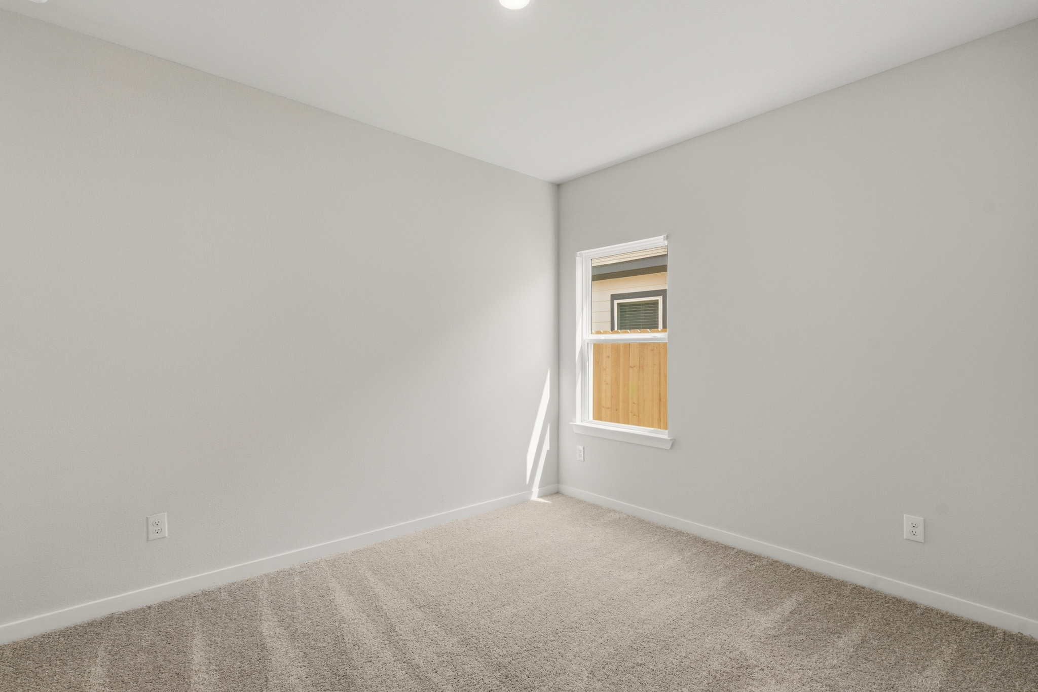 A room with a window and carpet.