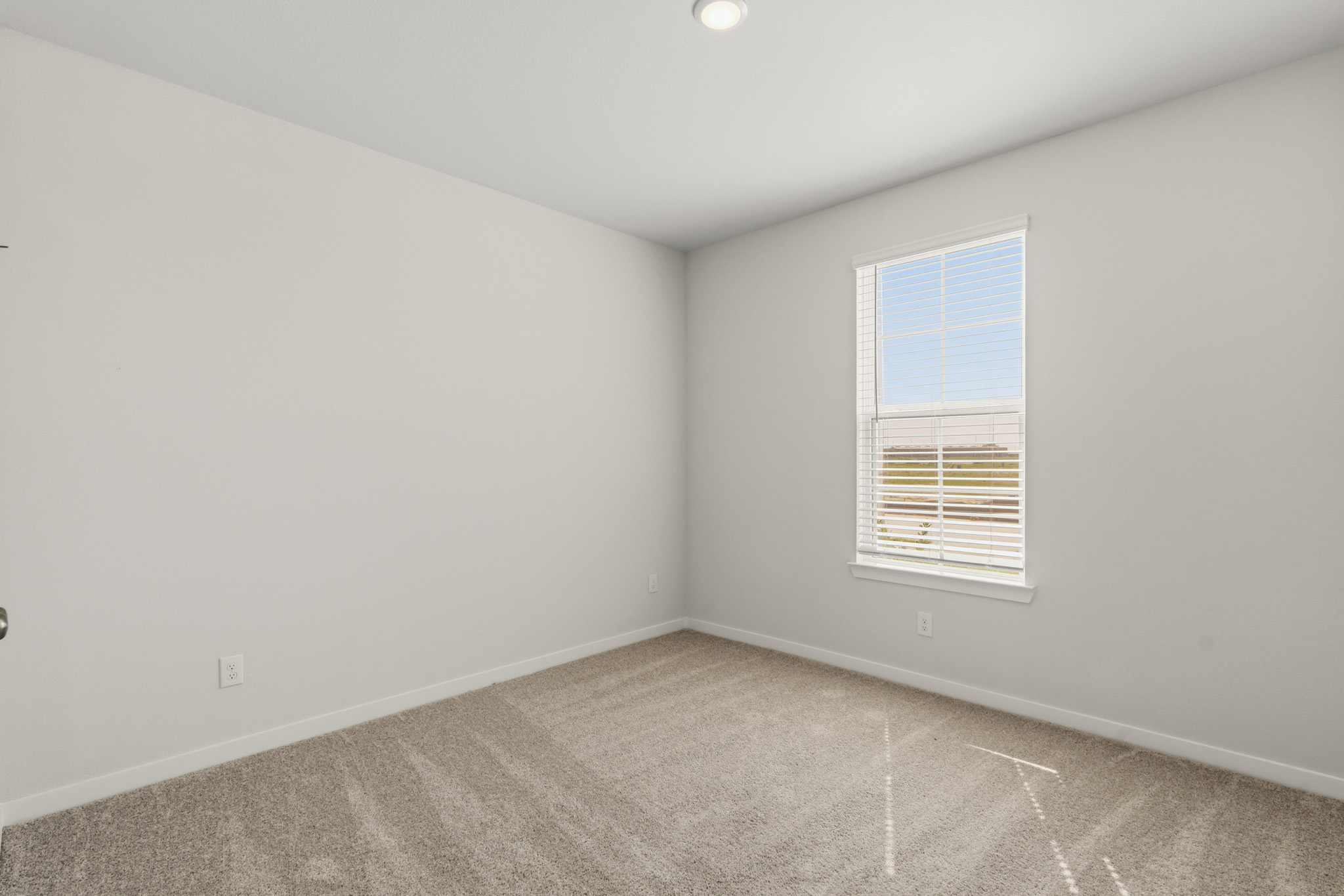 A room with a window and a carpet.