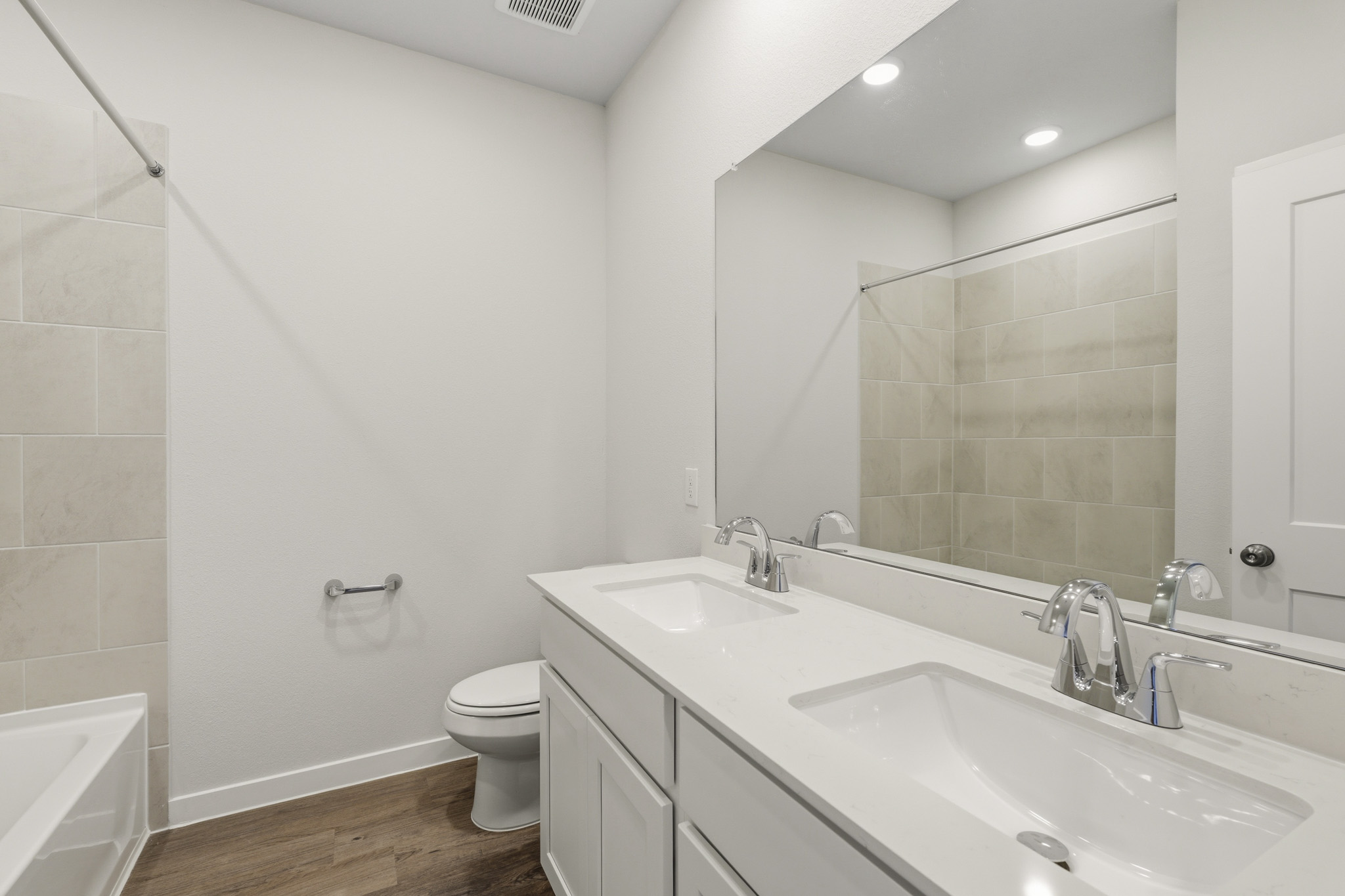 A bathroom with a large mirror.