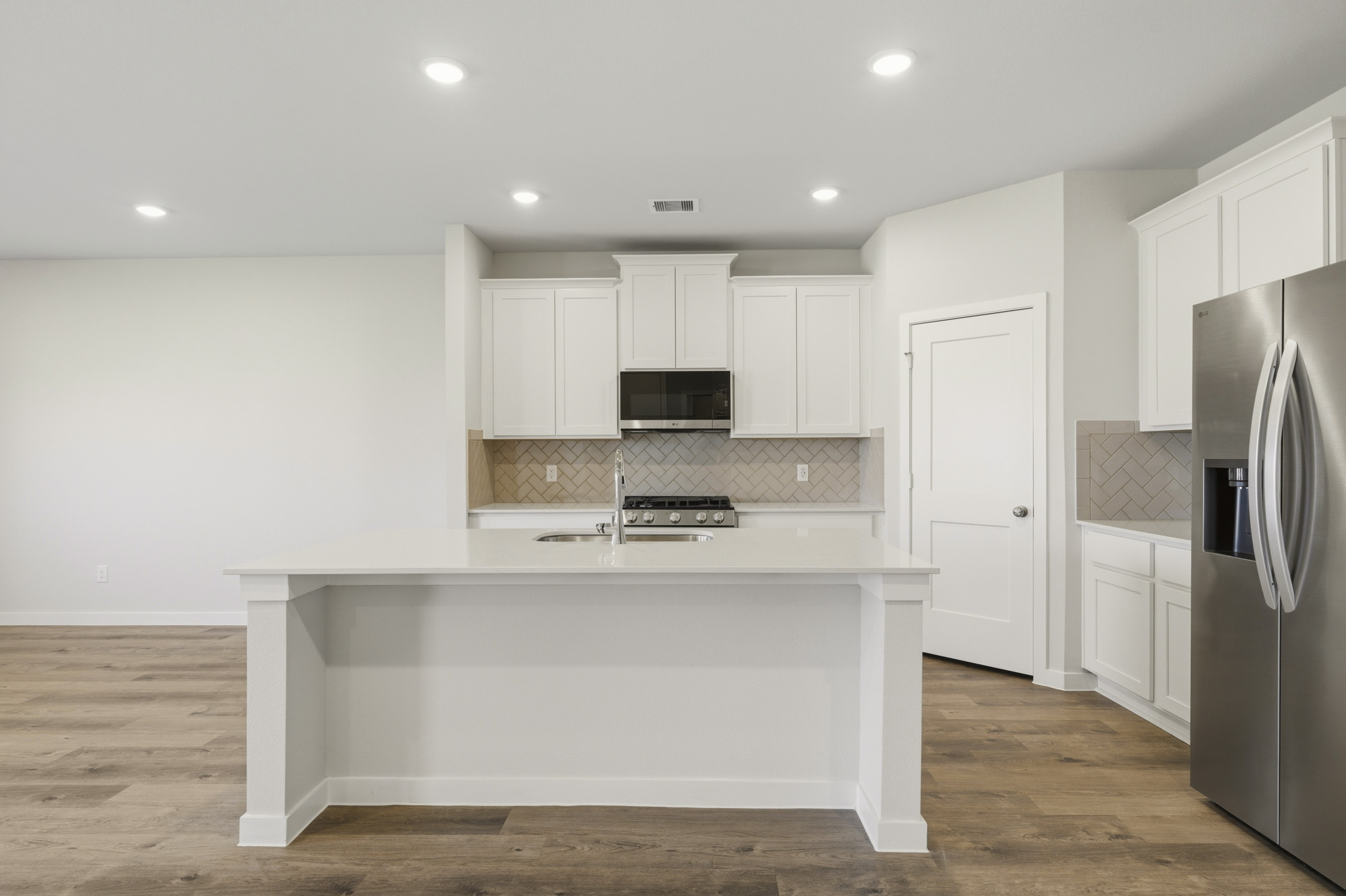 A kitchen with white cabinets.