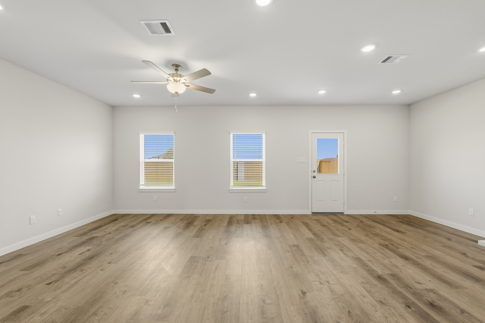 A room with a wood floor and a ceiling fan.