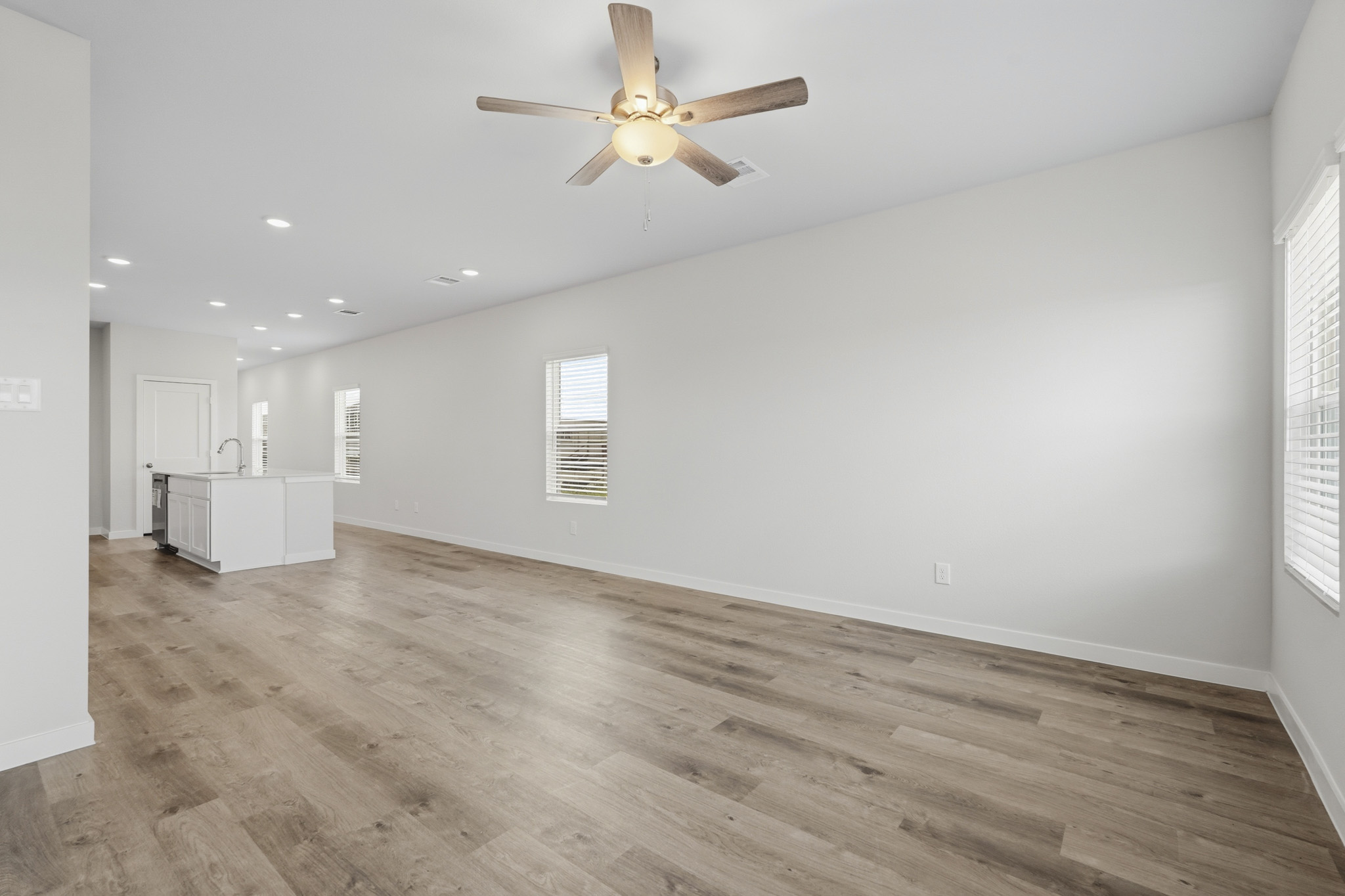 A room with a wood floor and a ceiling fan.