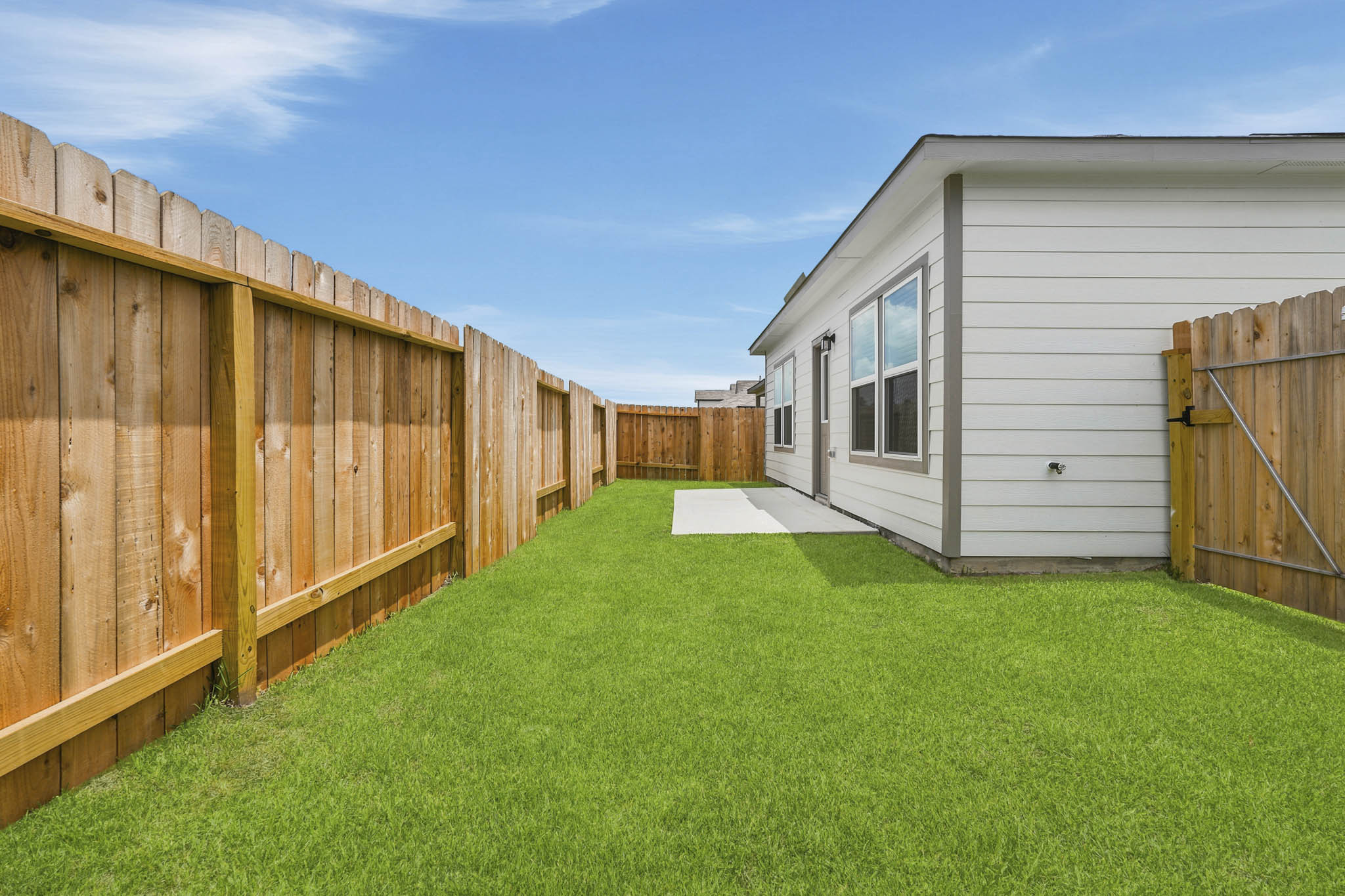 A fenced in yard with a house in the background.