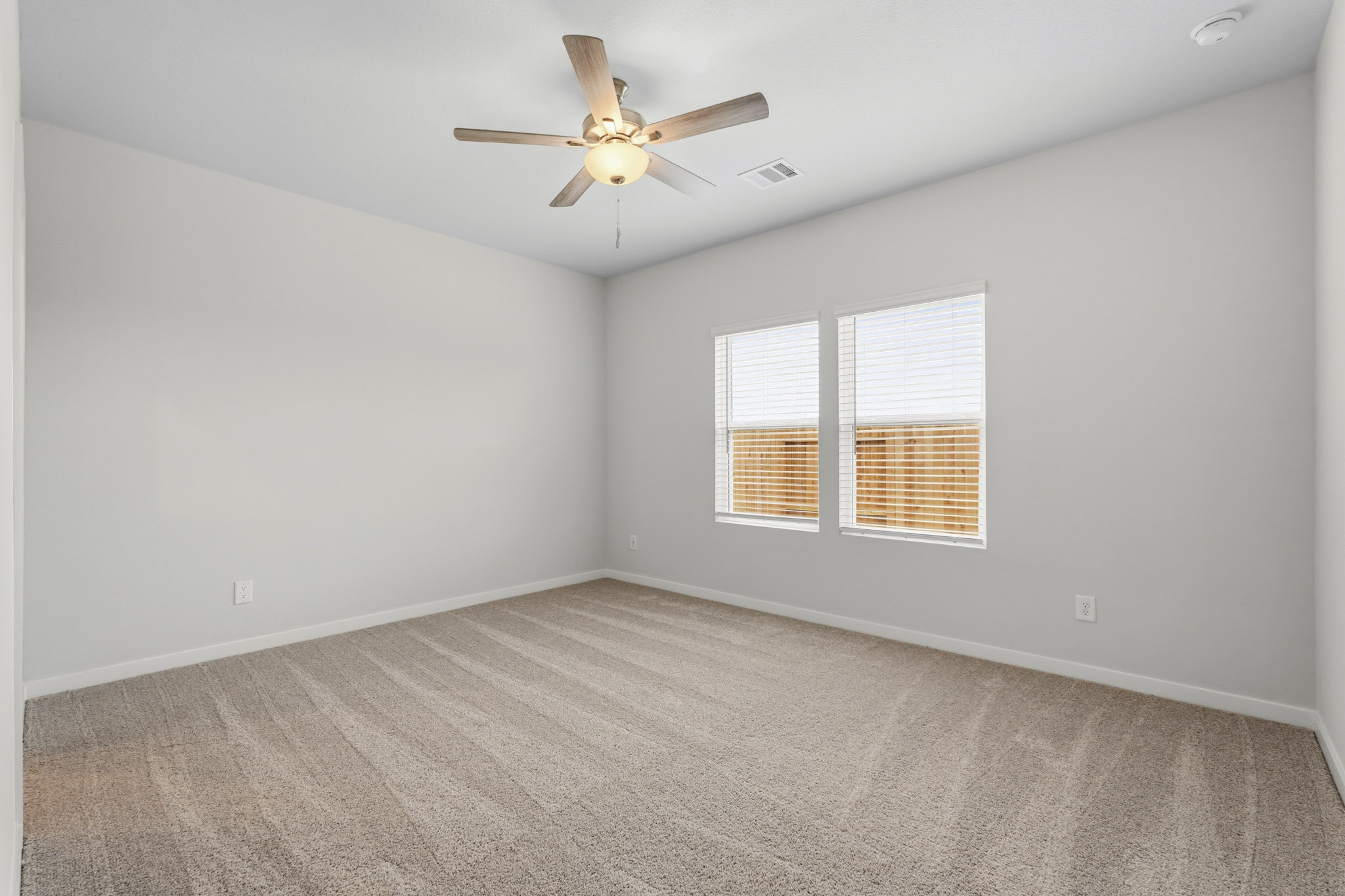 A room with a ceiling fan and a window.