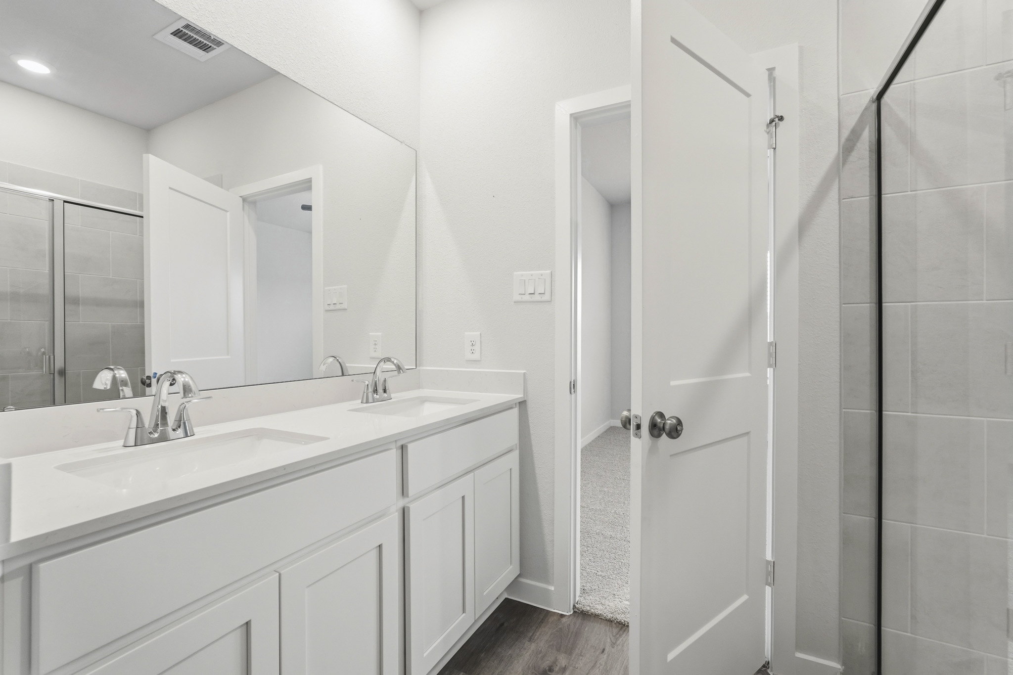 A bathroom with a sink and a shower unit.