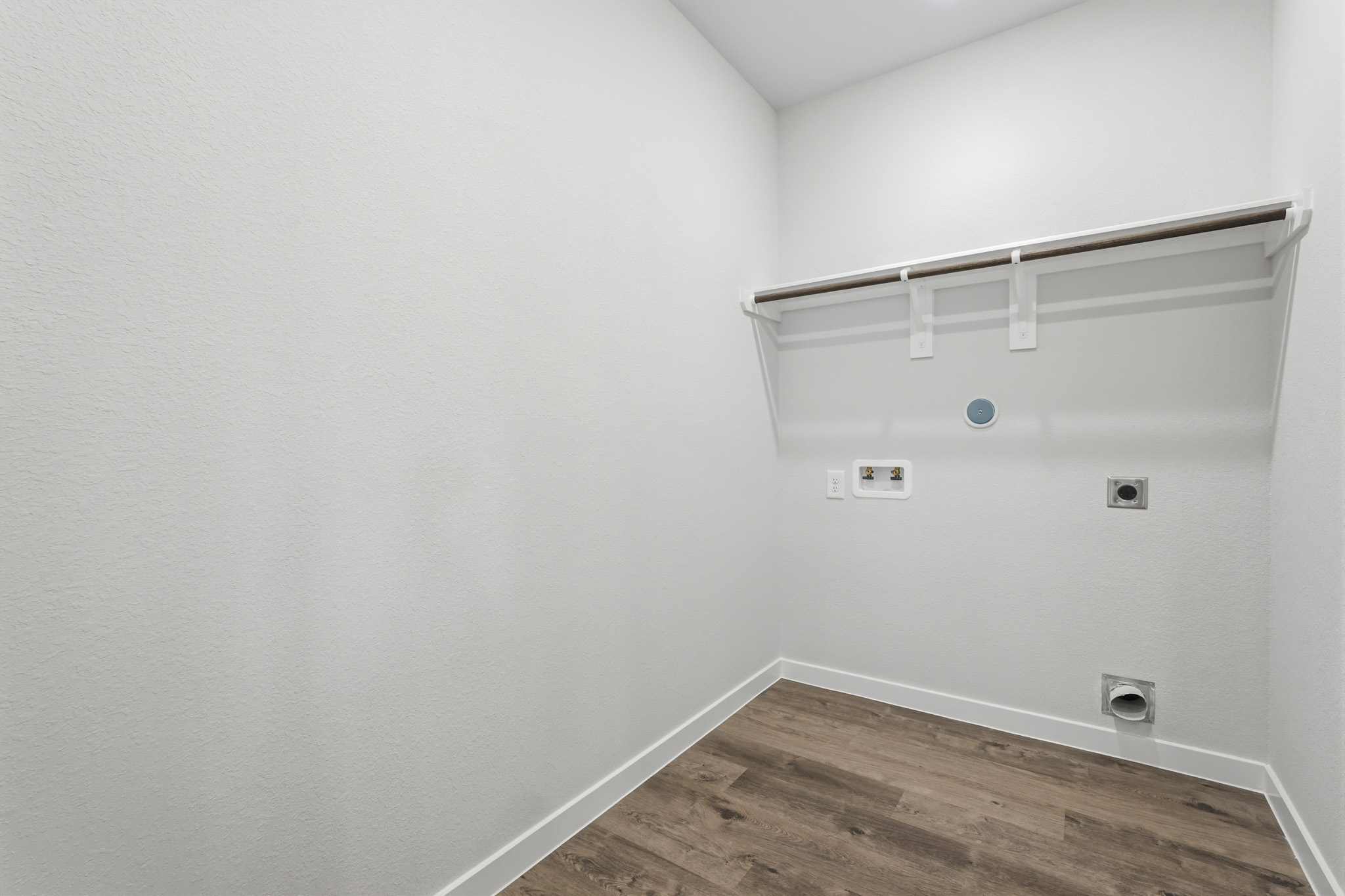 A white room with a wood floor.