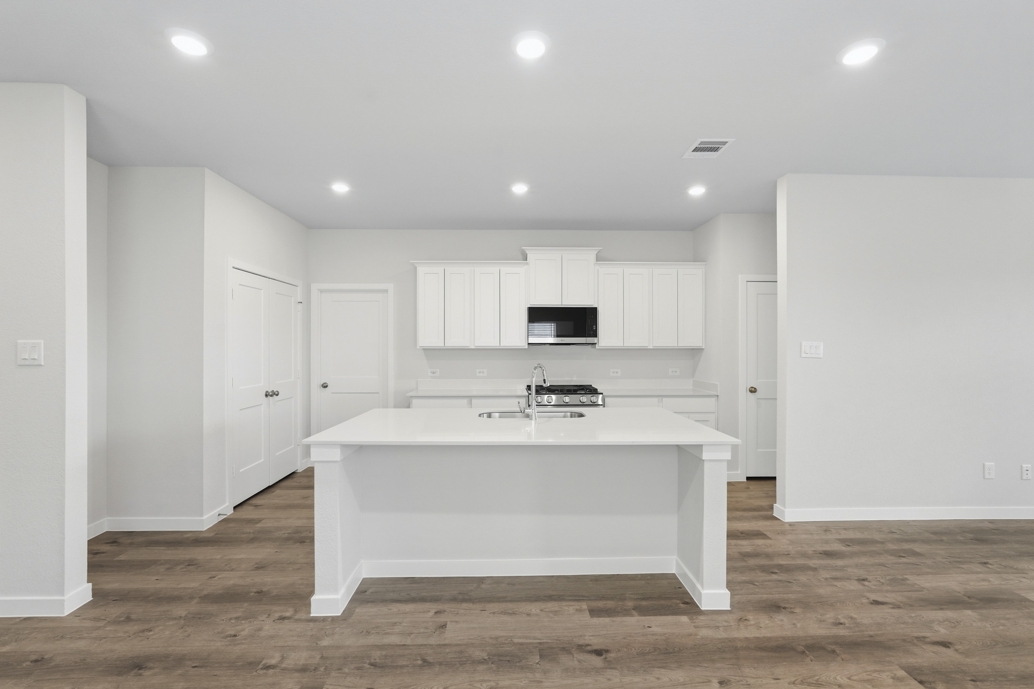 A kitchen with white cabinets.
