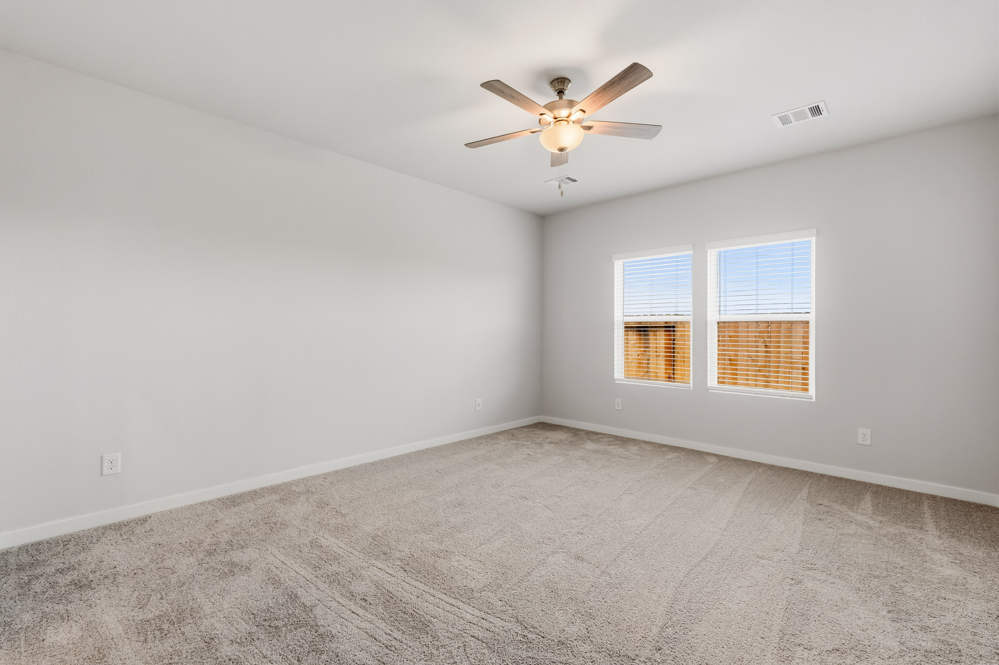 A room with a ceiling fan and a window.