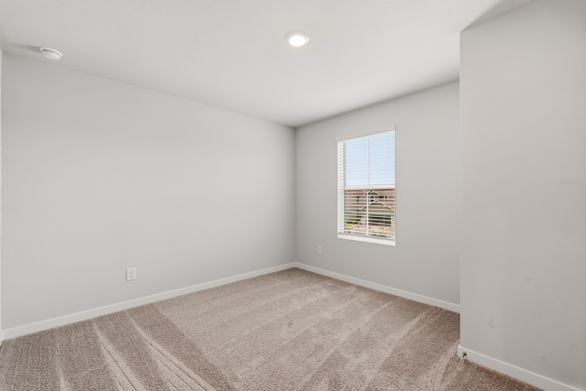 A room with a carpet and a window.