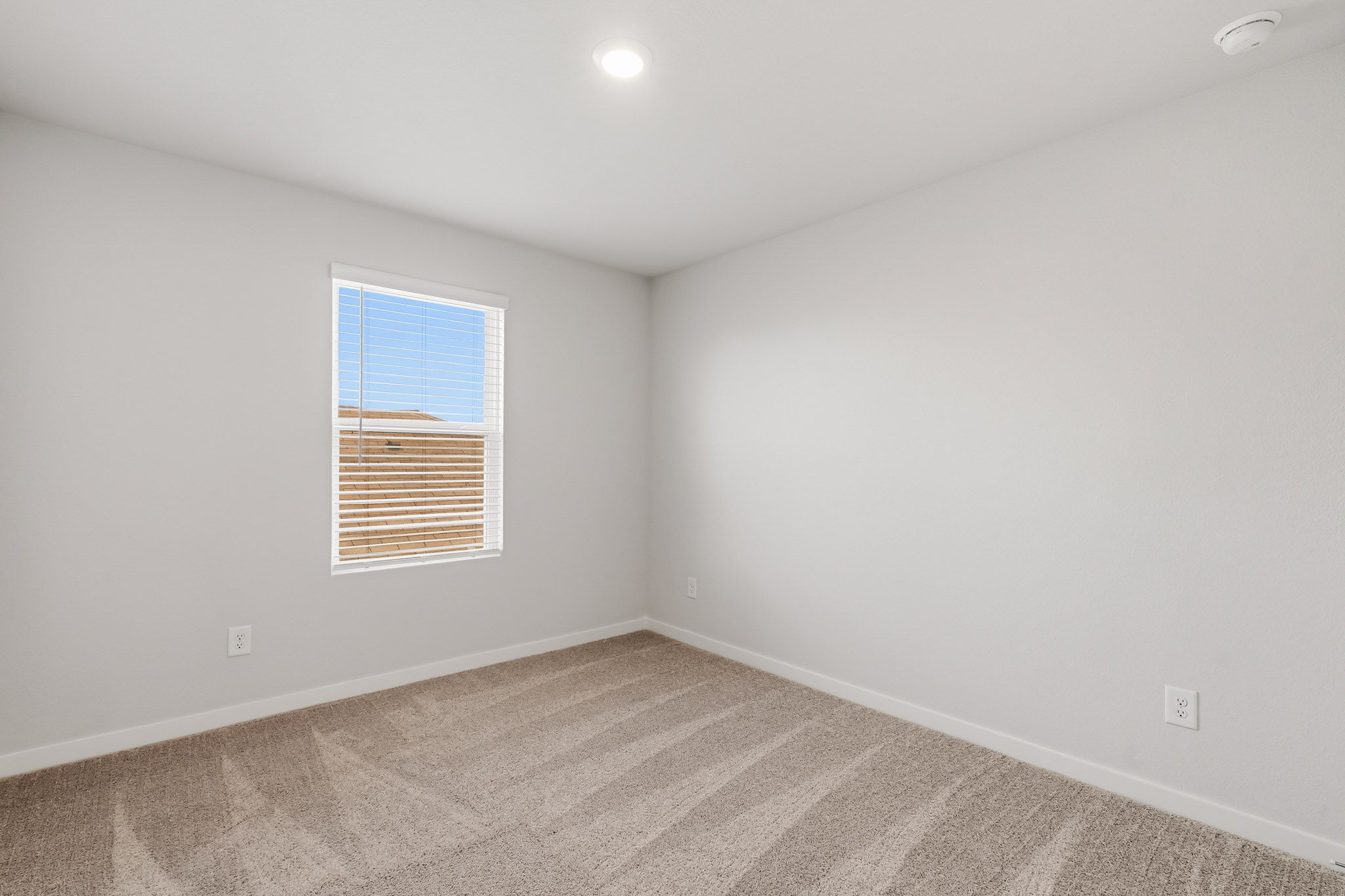 A room with a window and a carpet.