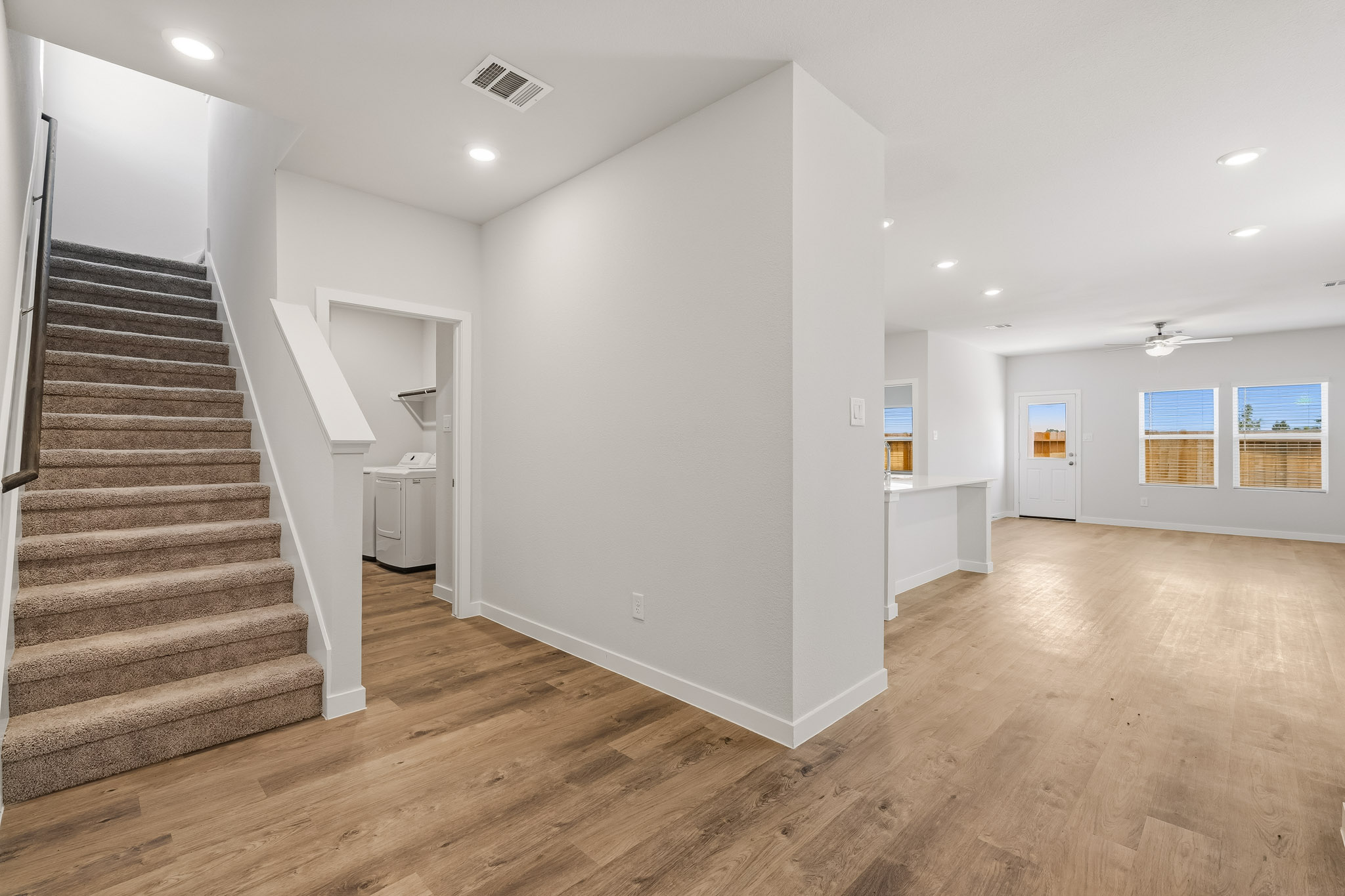 A large empty room with a wood floor and white walls.