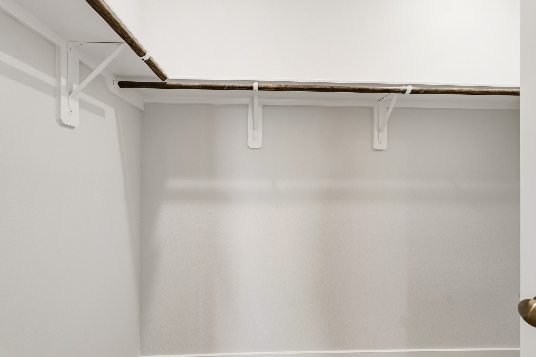 A white wall with a metal bar.