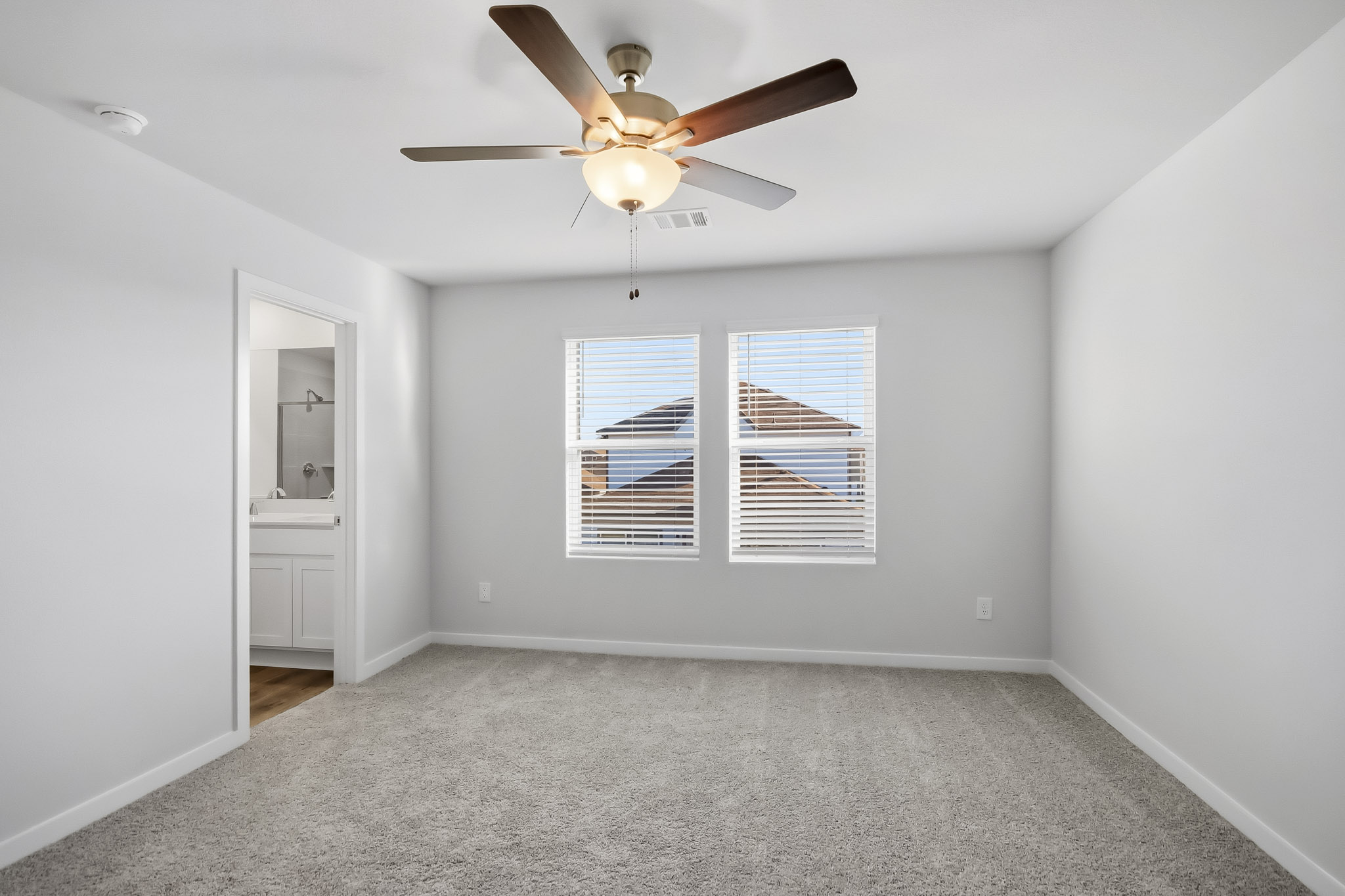 A room with a ceiling fan and a window.