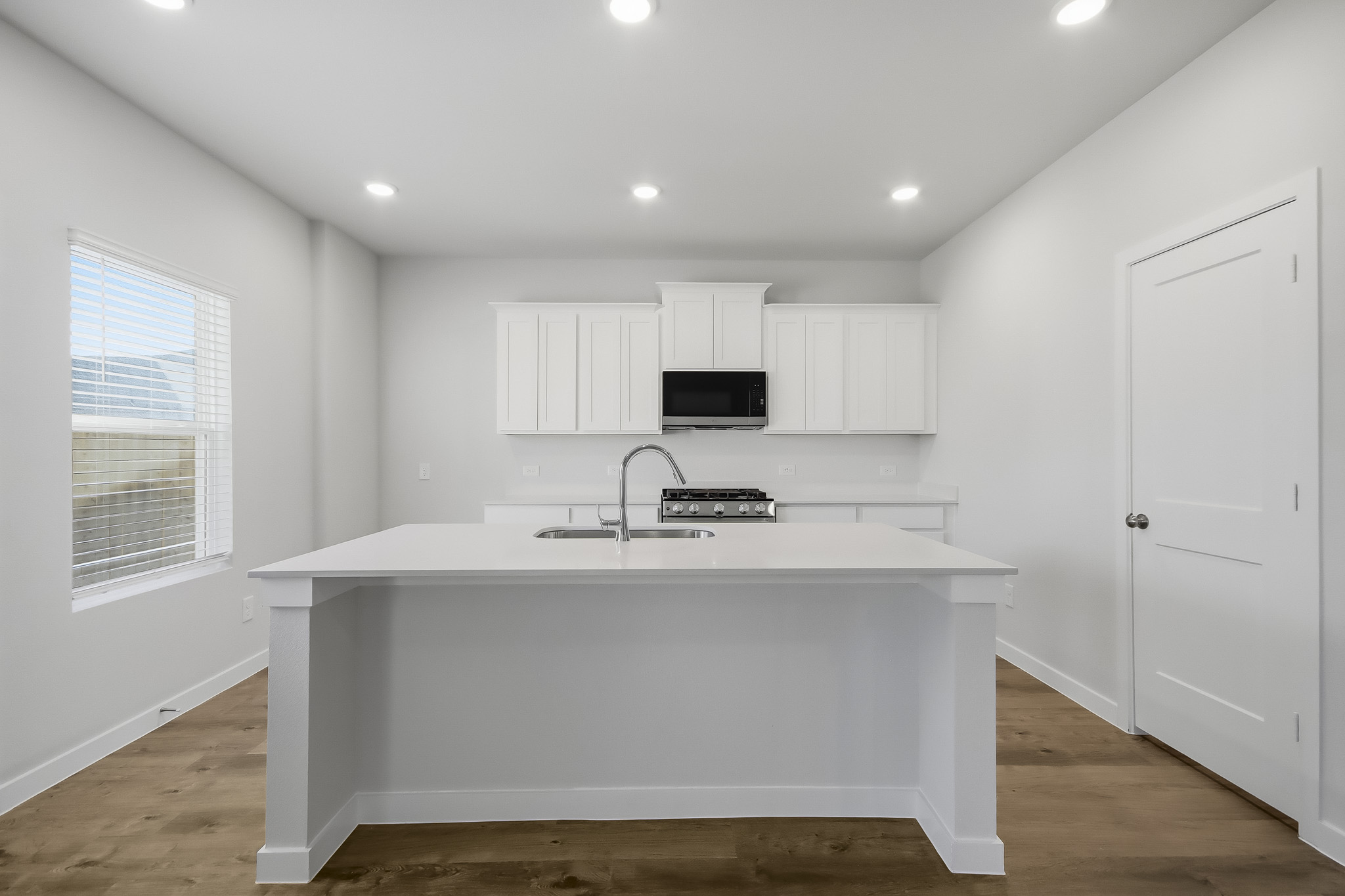 A kitchen with white cabinets.