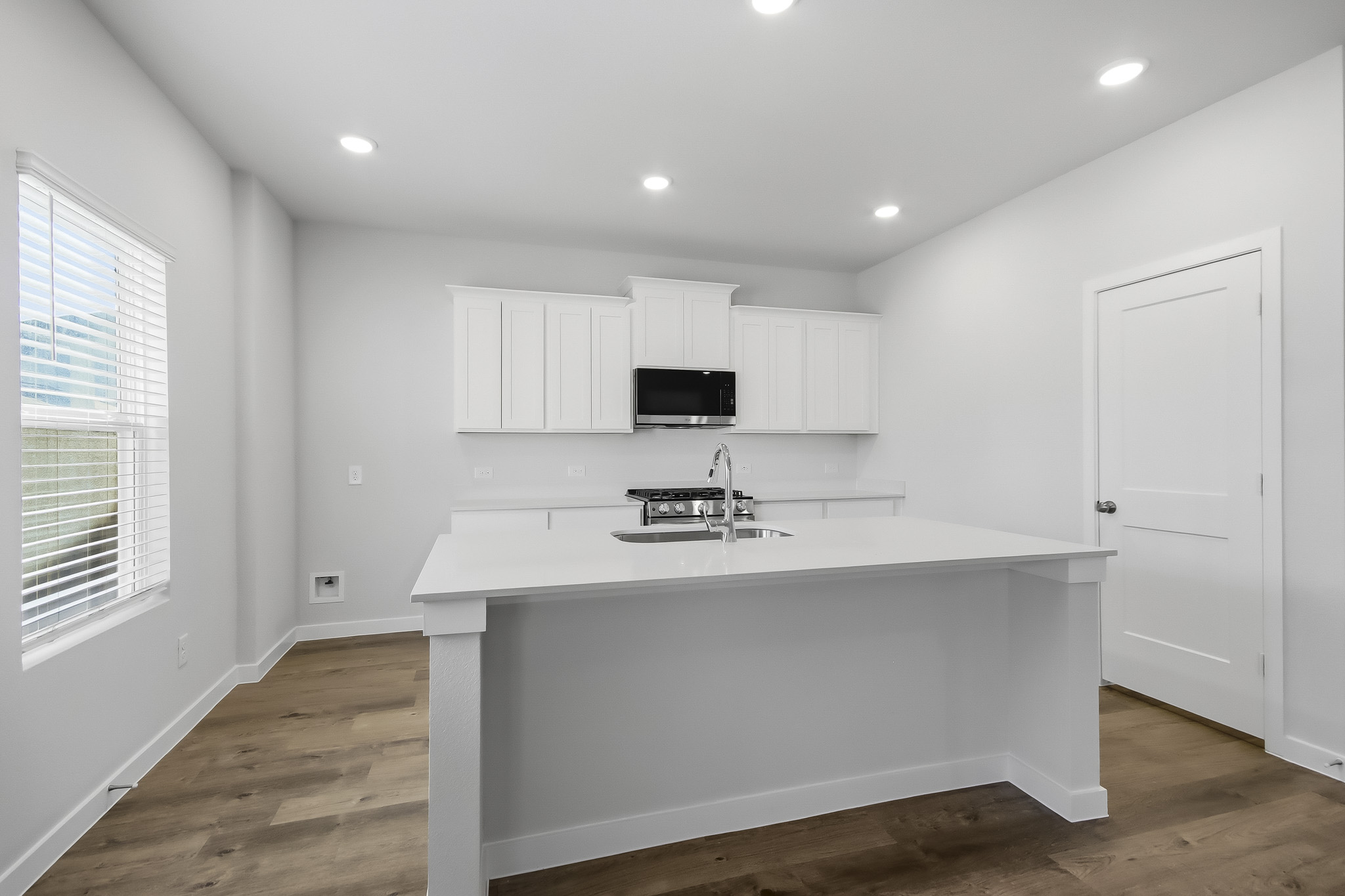 A kitchen with white cabinets.