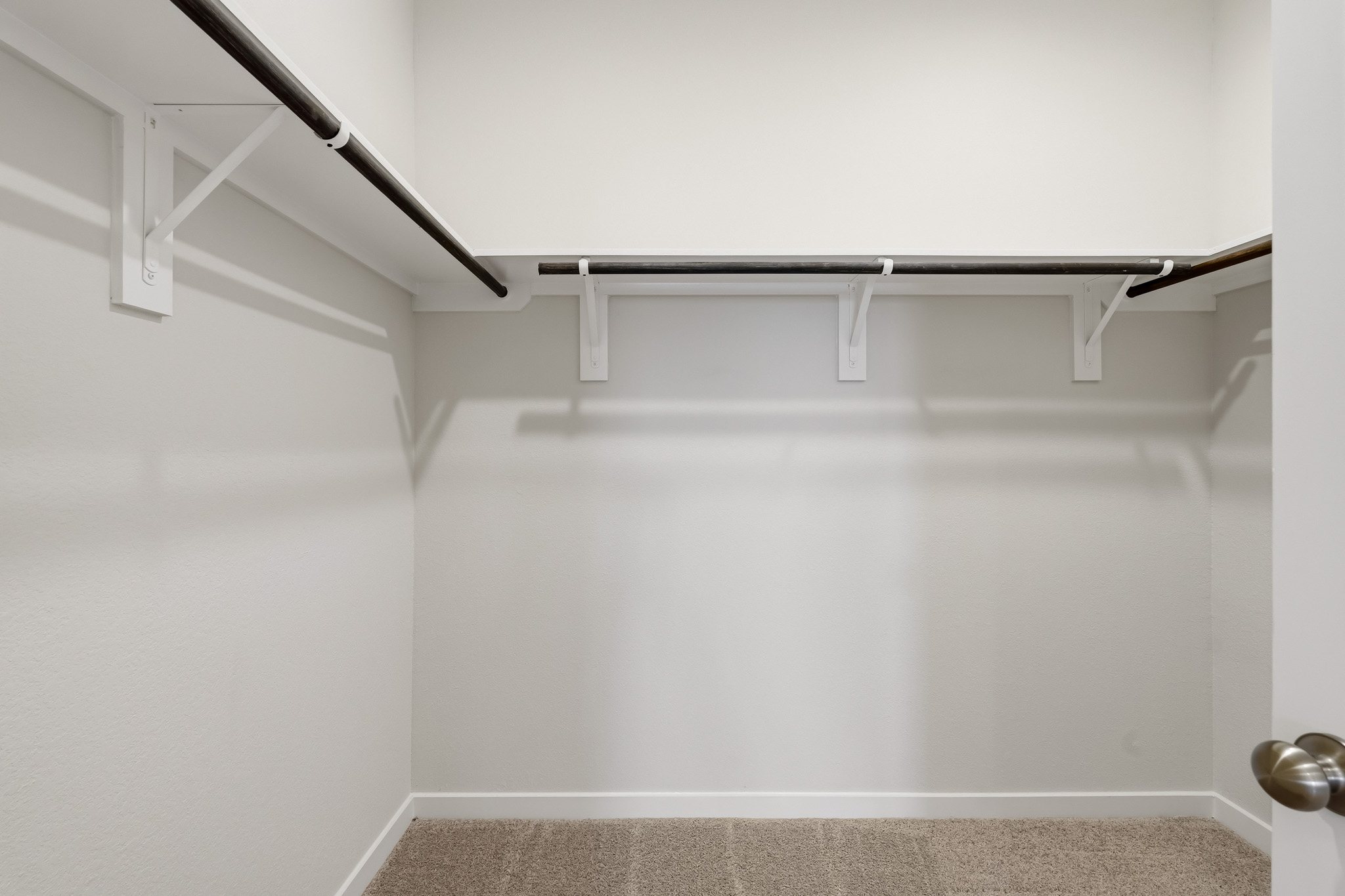 A white wall with a metal railing.