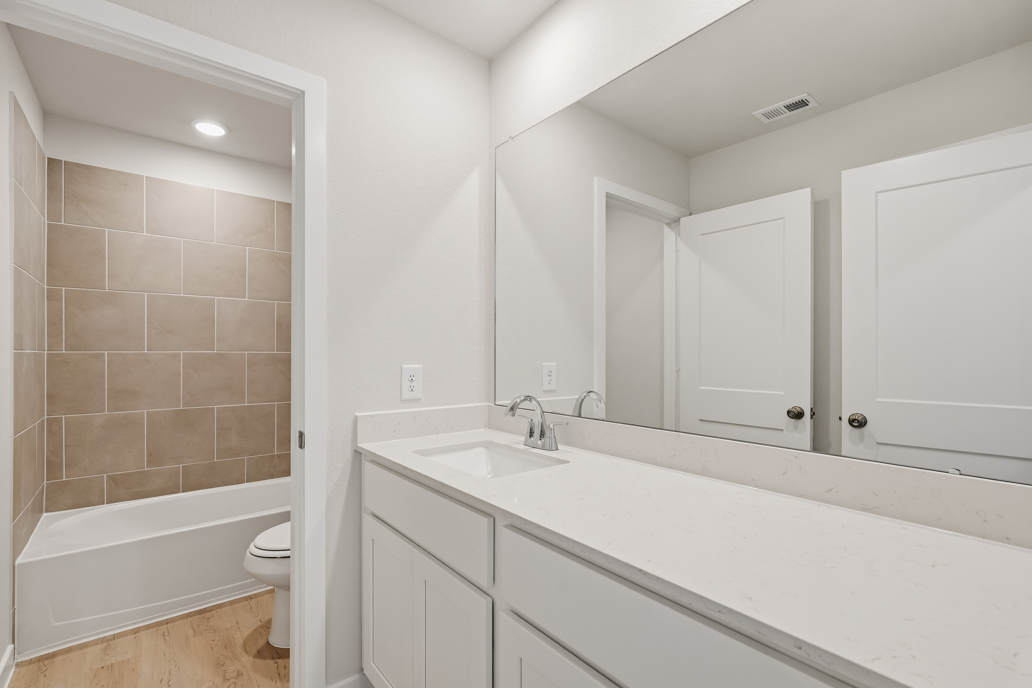 A bathroom with a tub sink and toilet.
