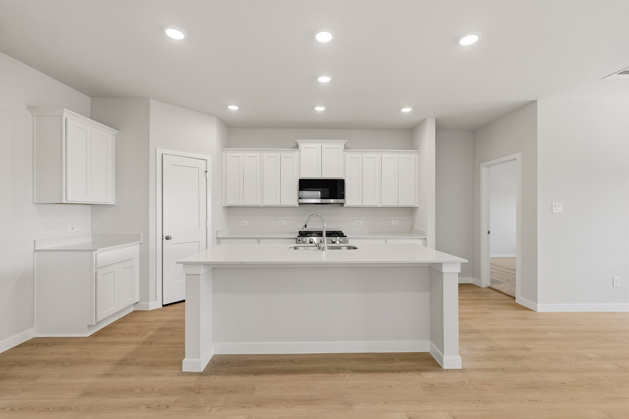 A kitchen with white cabinets.