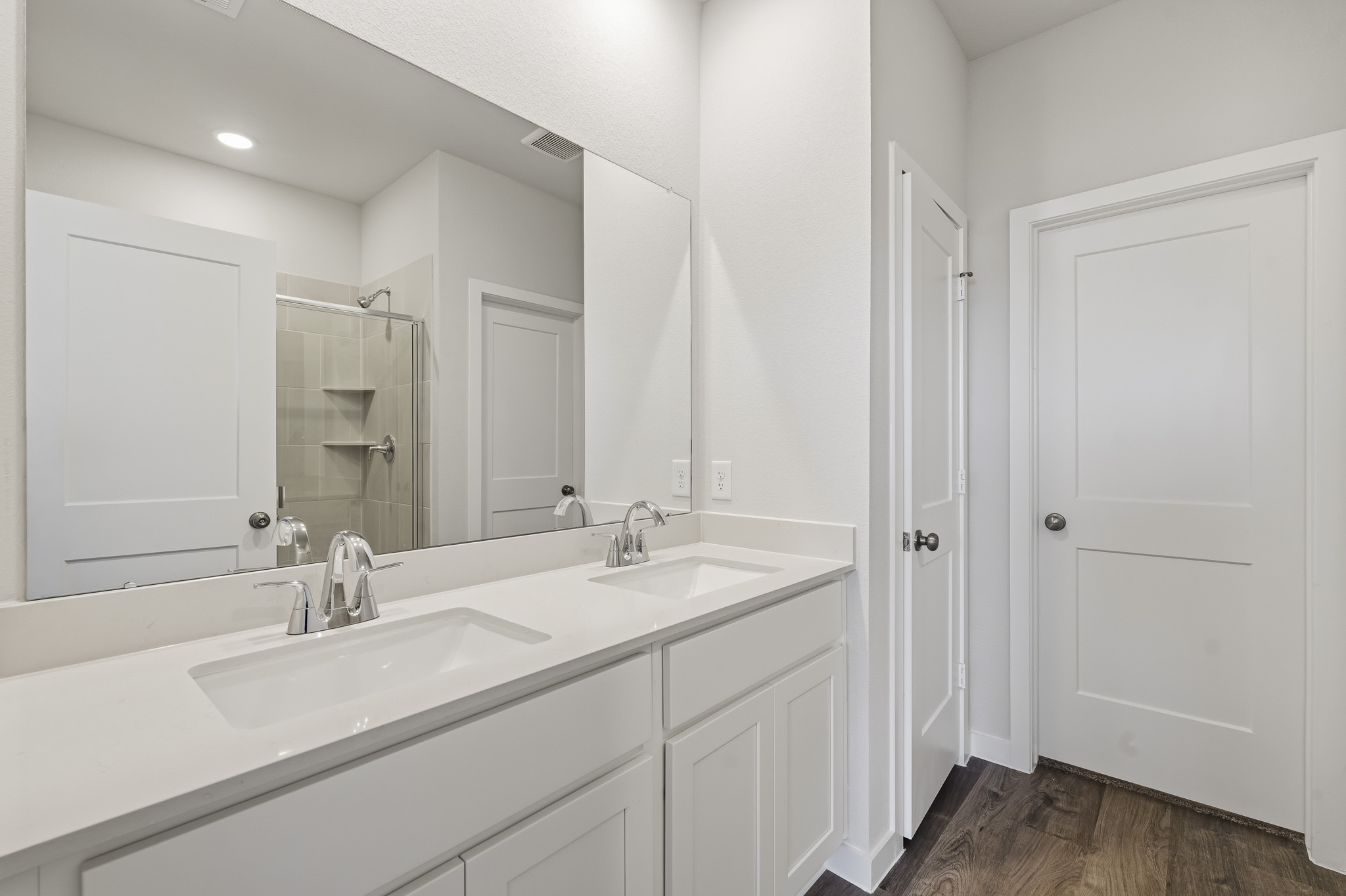 A bathroom with white cabinets.