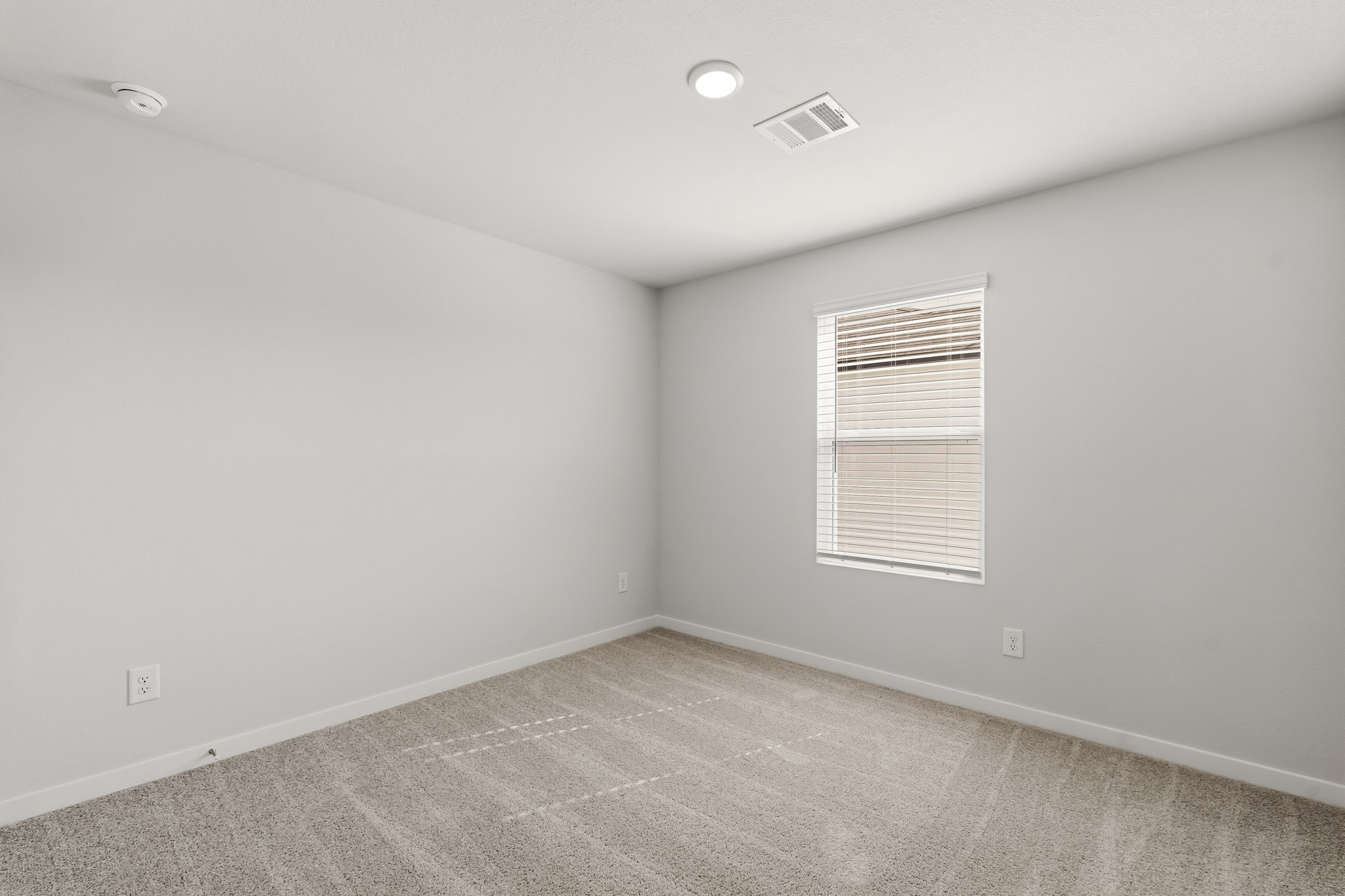 A room with a carpet and a window.