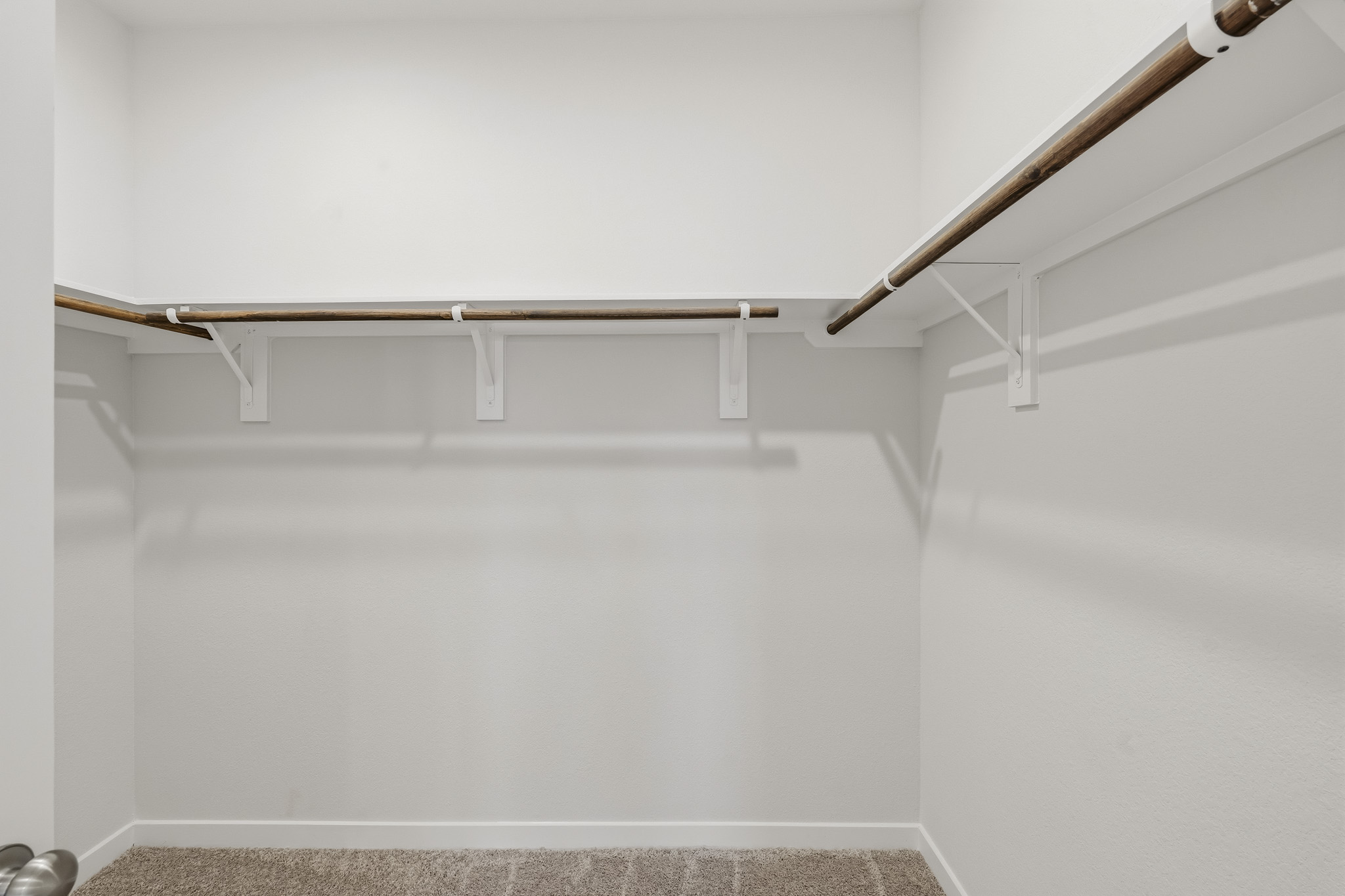A white wall with a metal bar.
