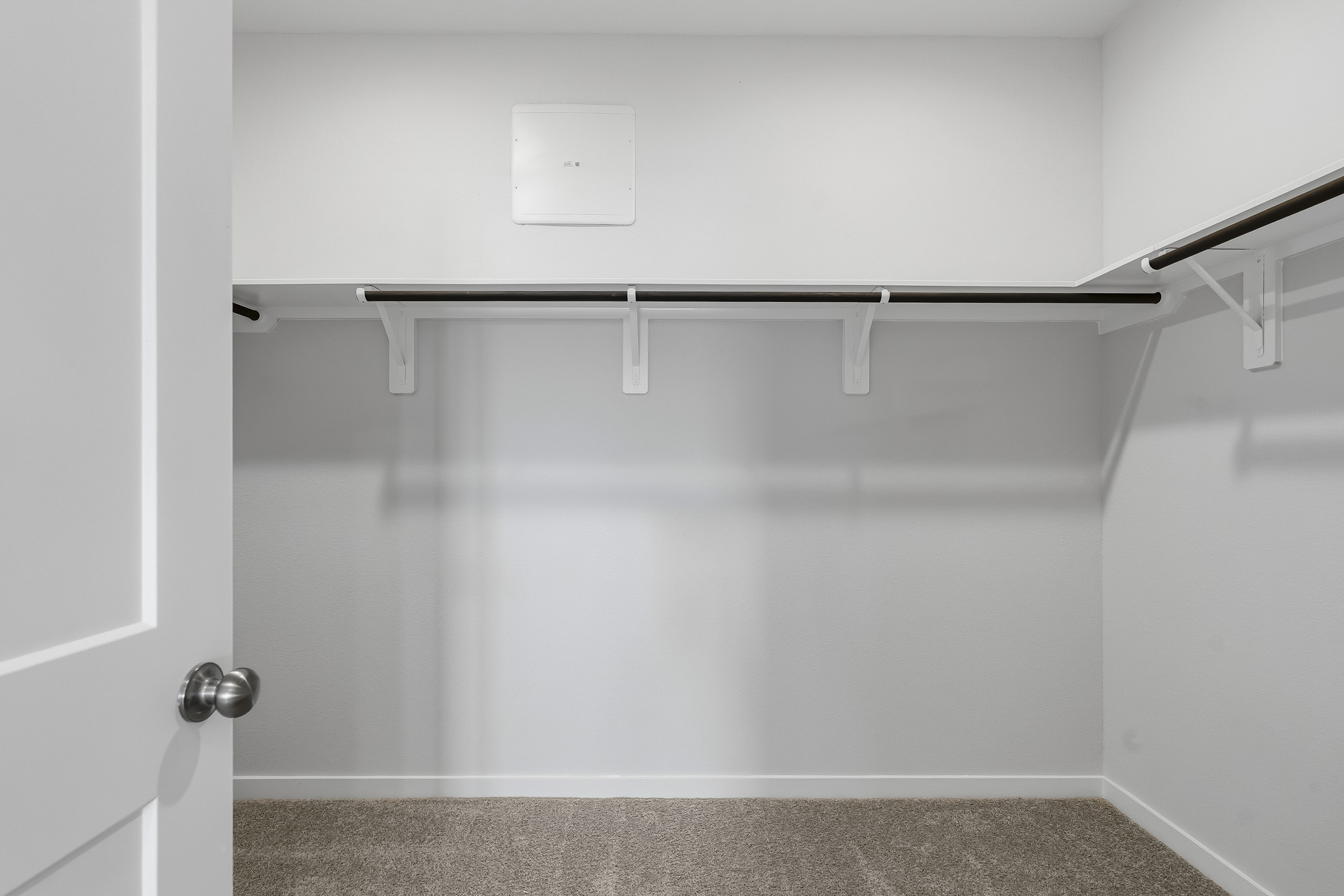 A white wall with a metal bar.