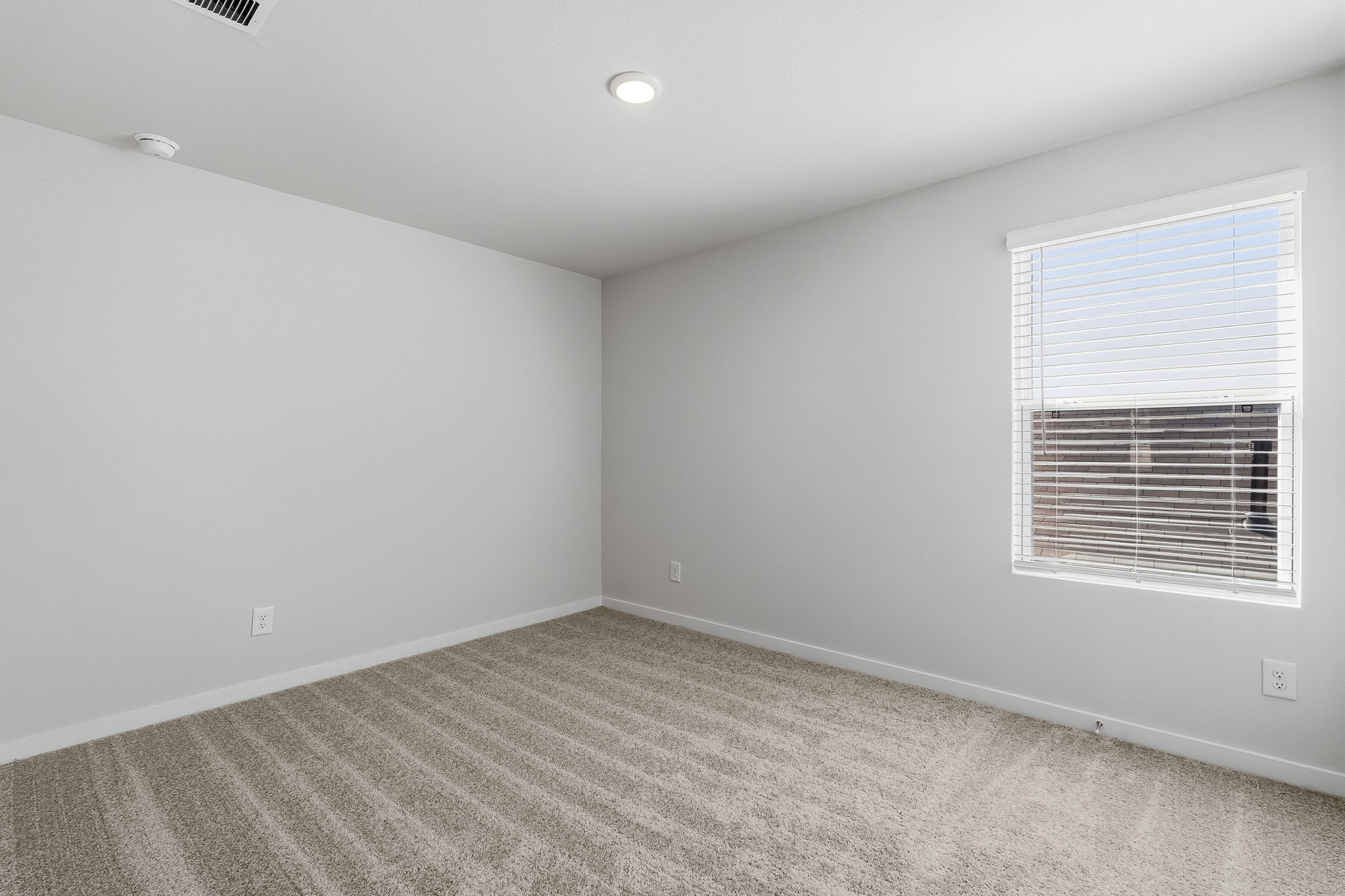 A room with a window and a carpet.