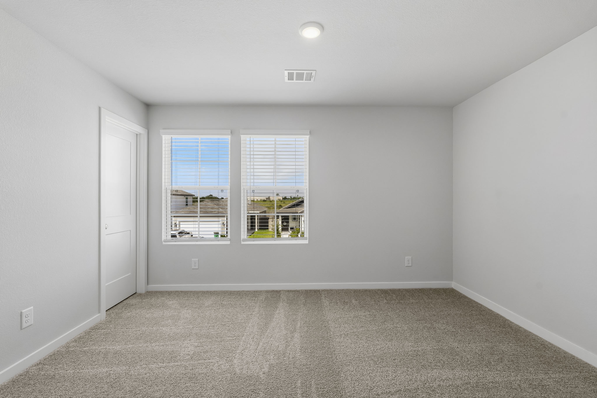 A room with a window and a carpet.