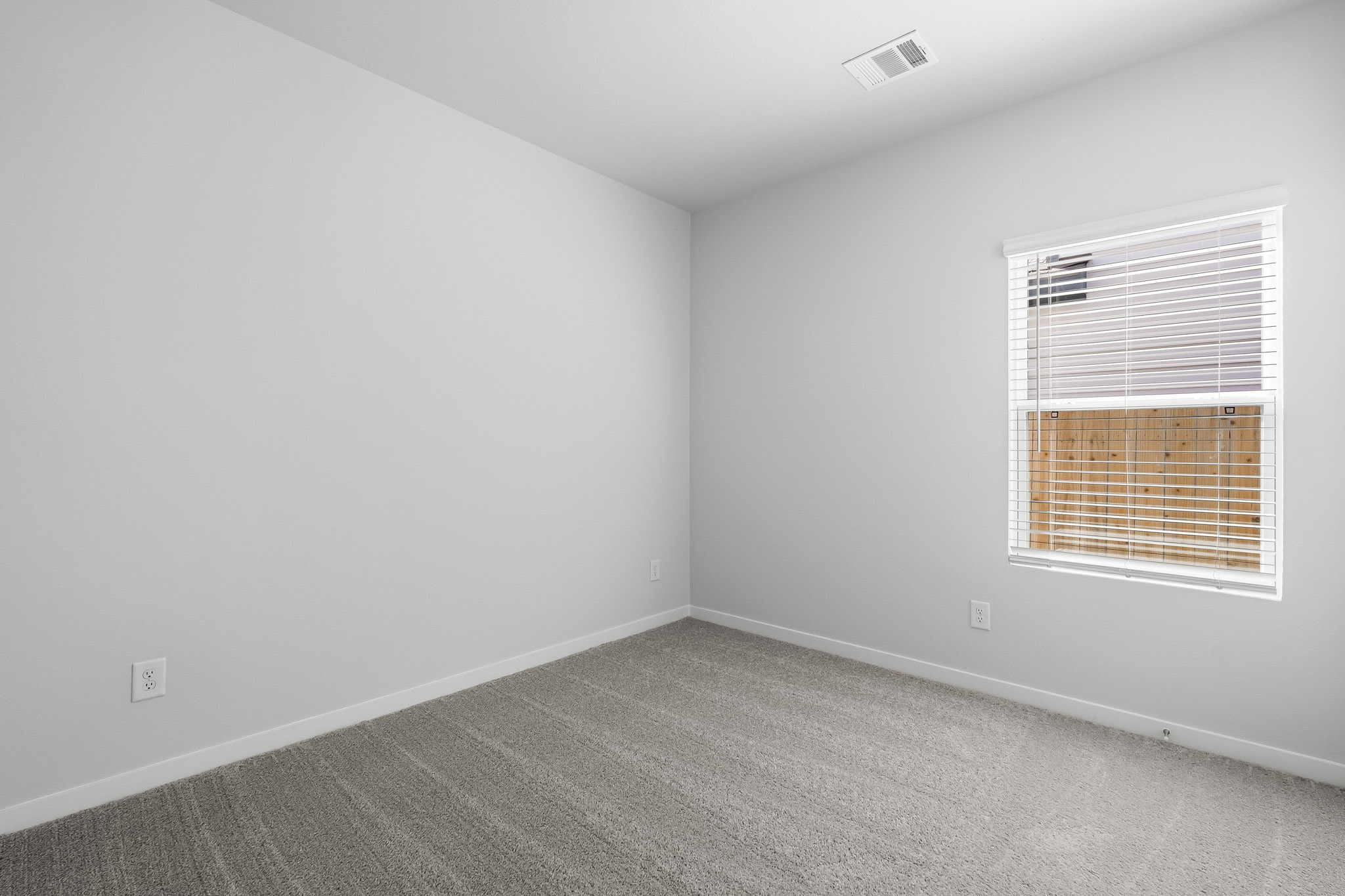 A room with a window and a carpet.