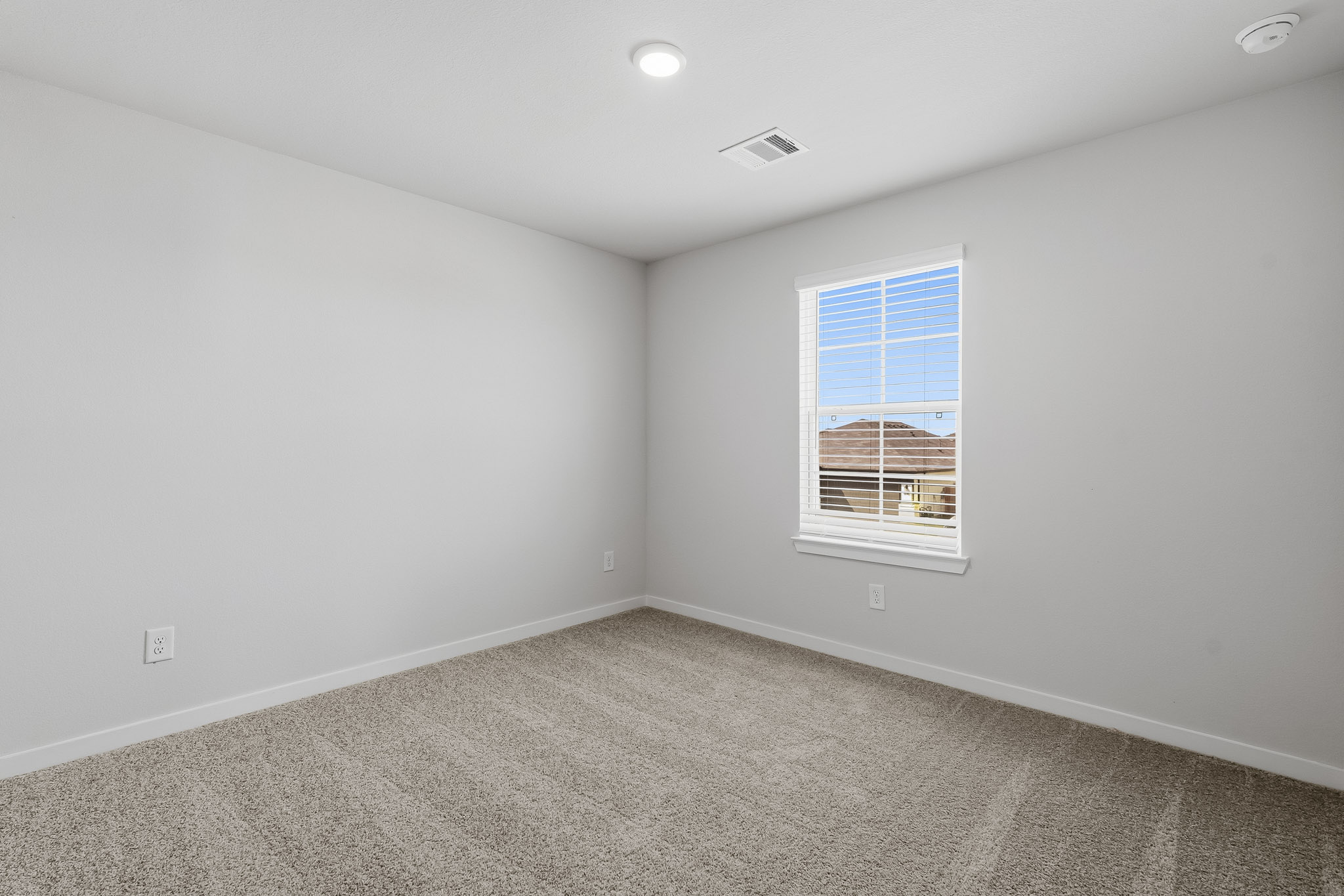 A room with a window and a carpet.