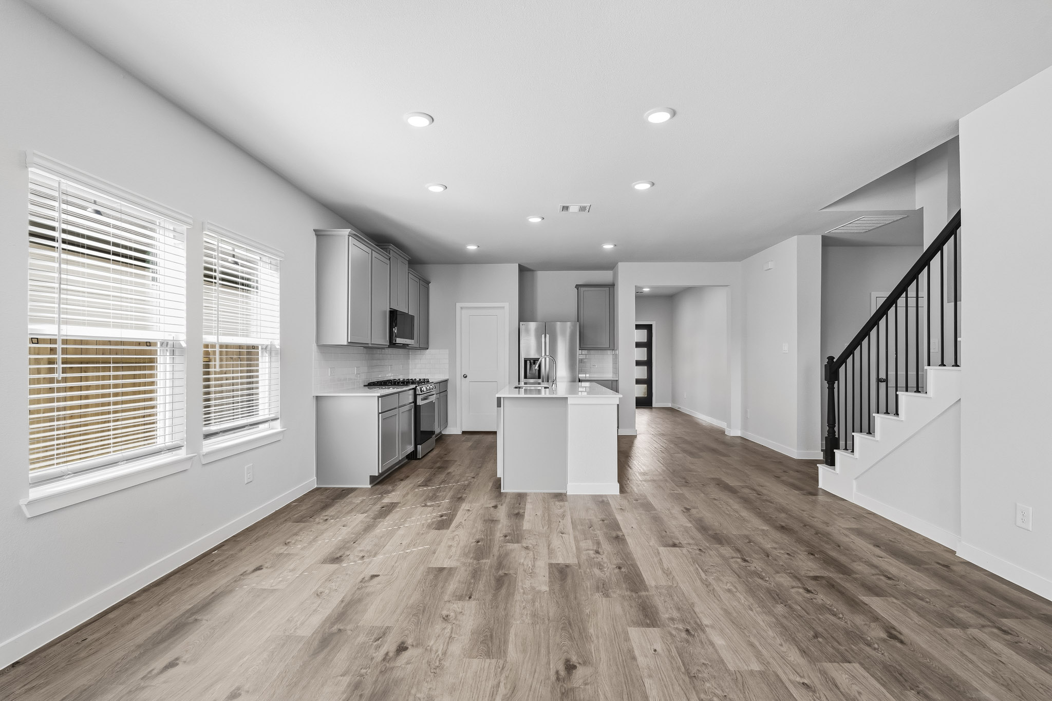 A large white kitchen with wood floors.
