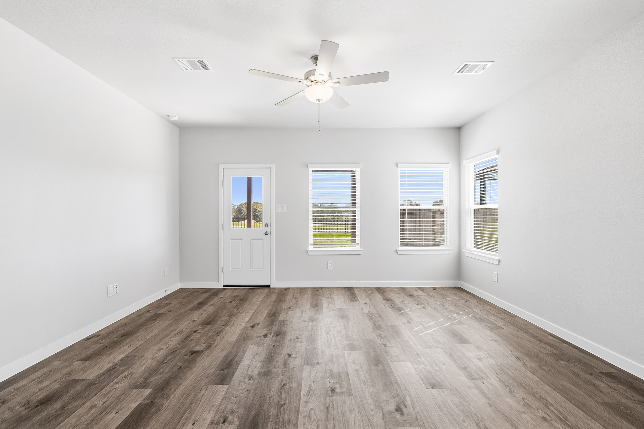 A room with a wood floor and a ceiling fan.