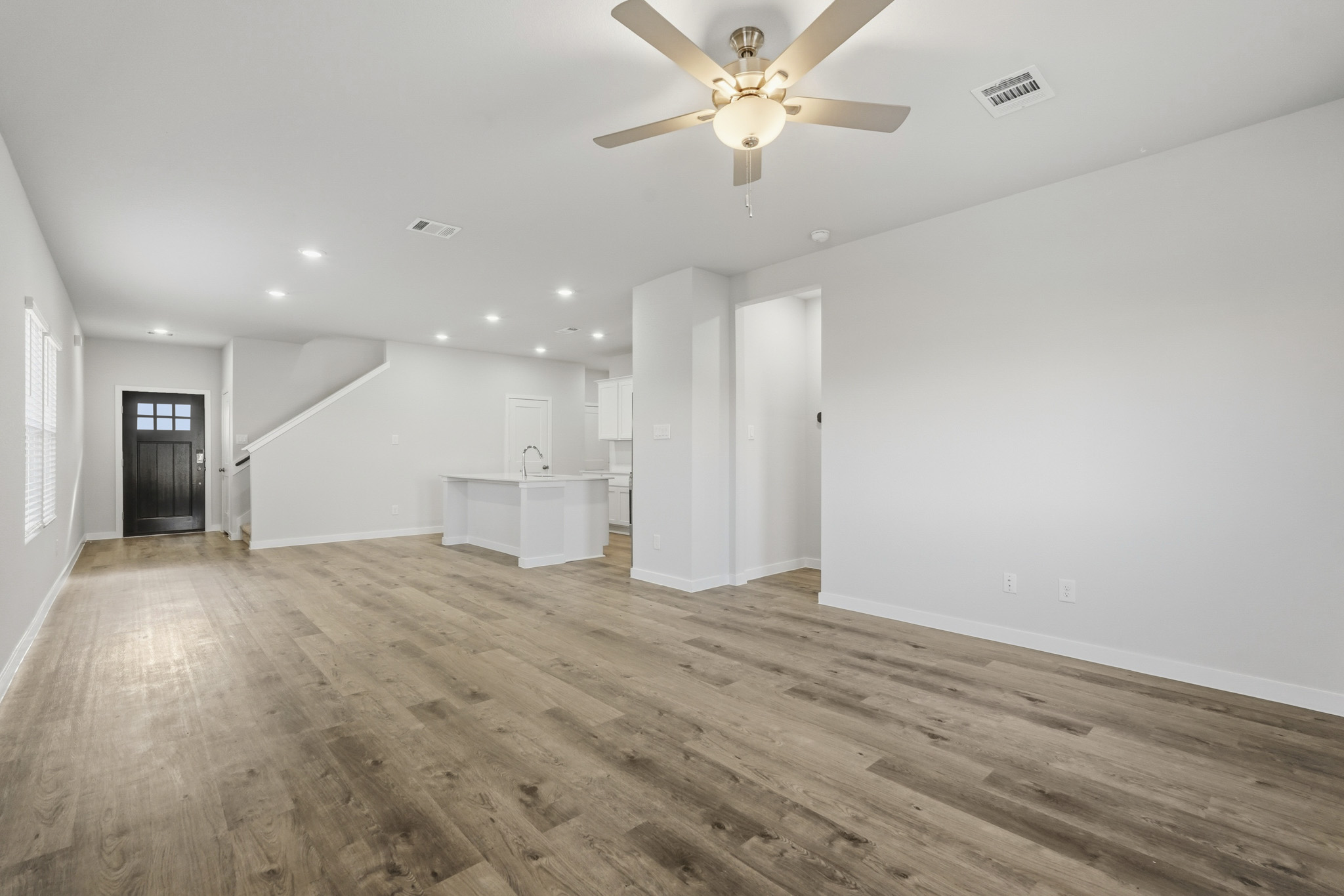A room with a wood floor and a ceiling fan.