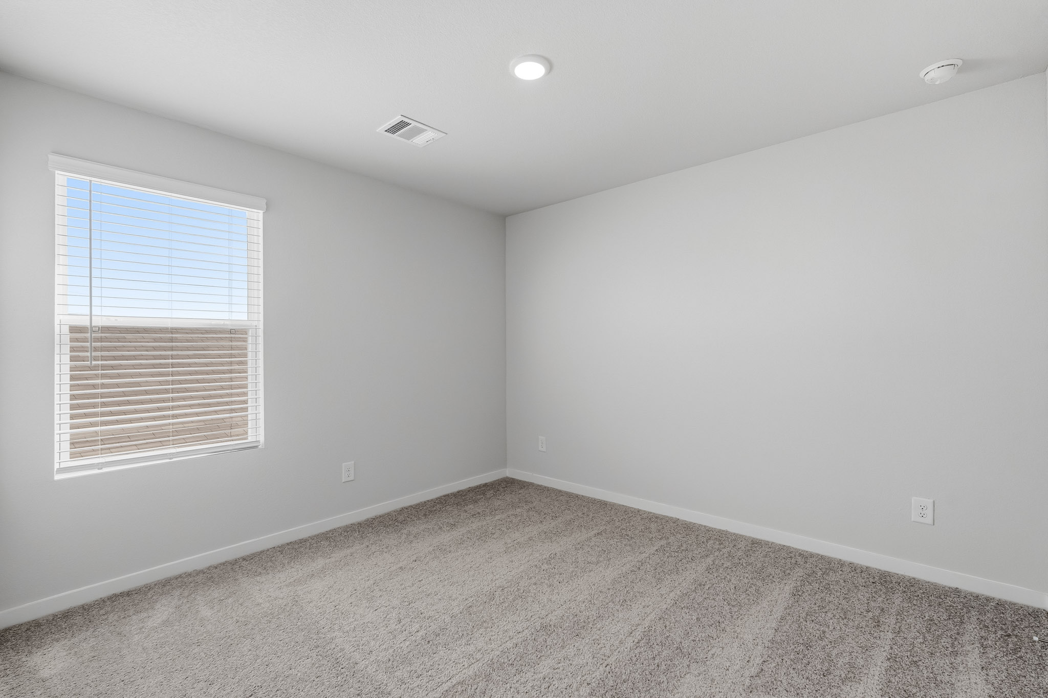 A room with a window and a carpet.