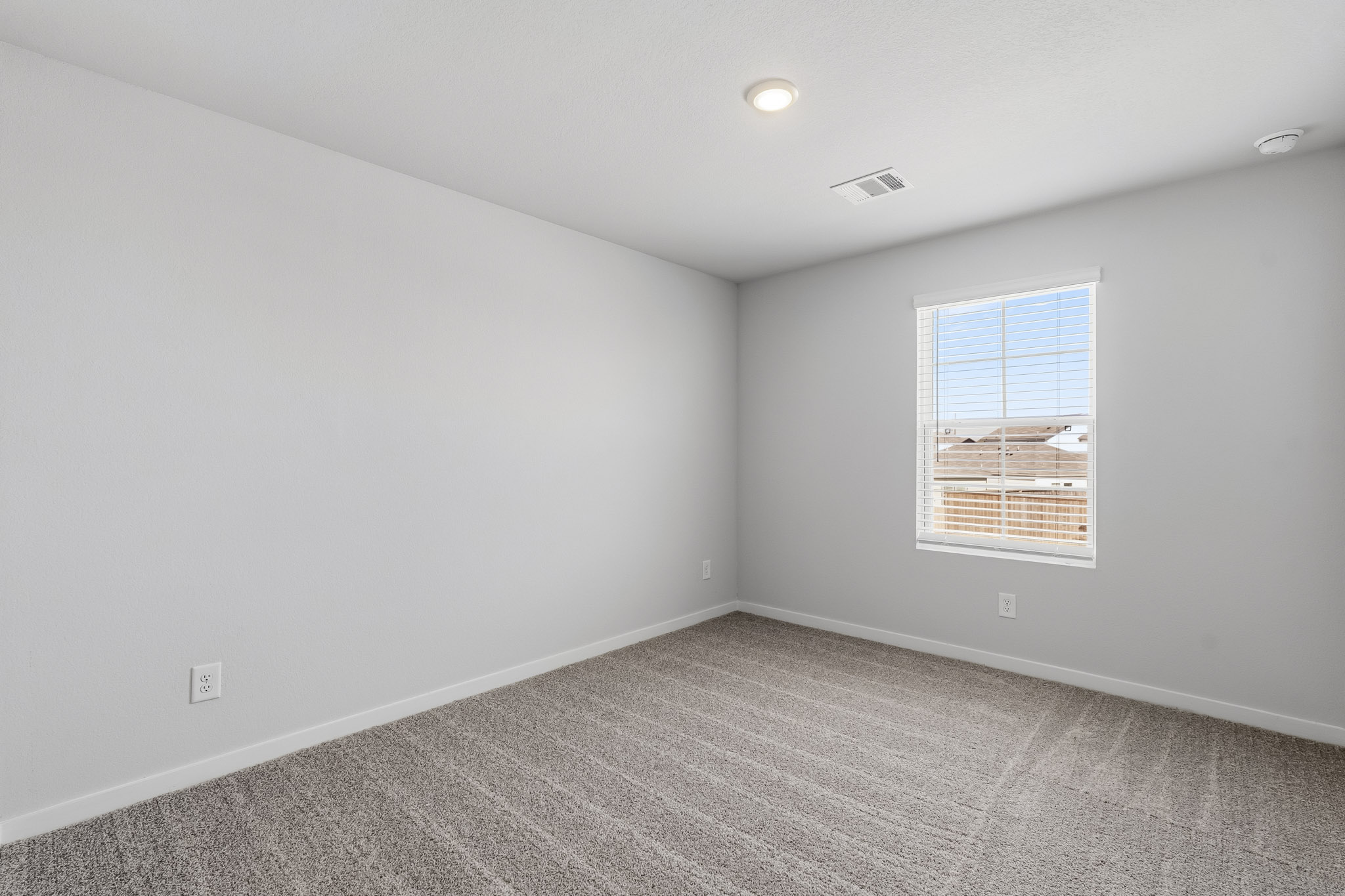 A room with a window and a carpet.