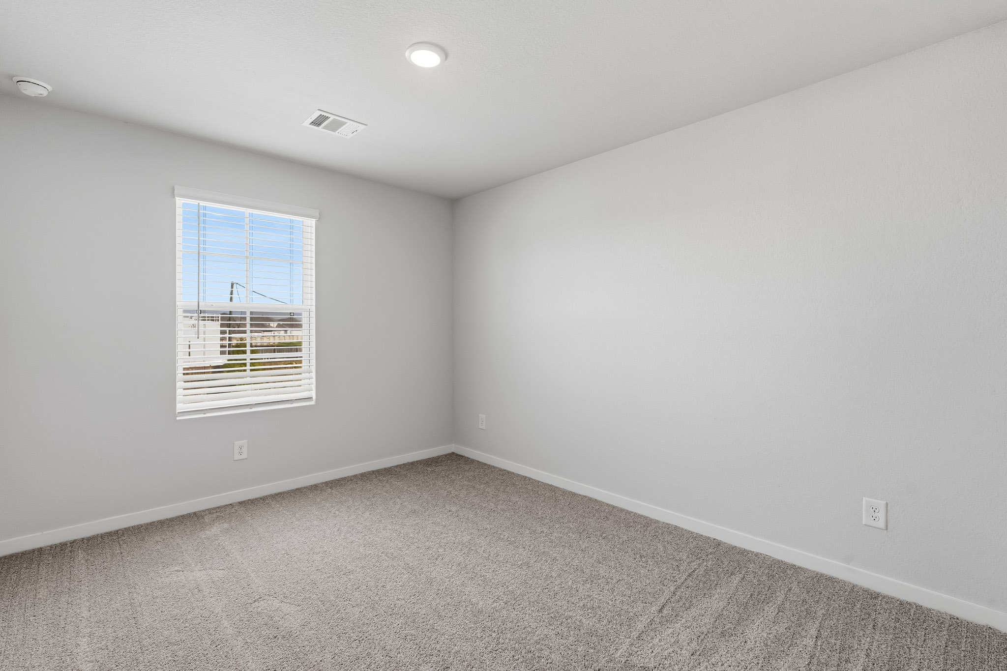 A room with a window and a carpet.
