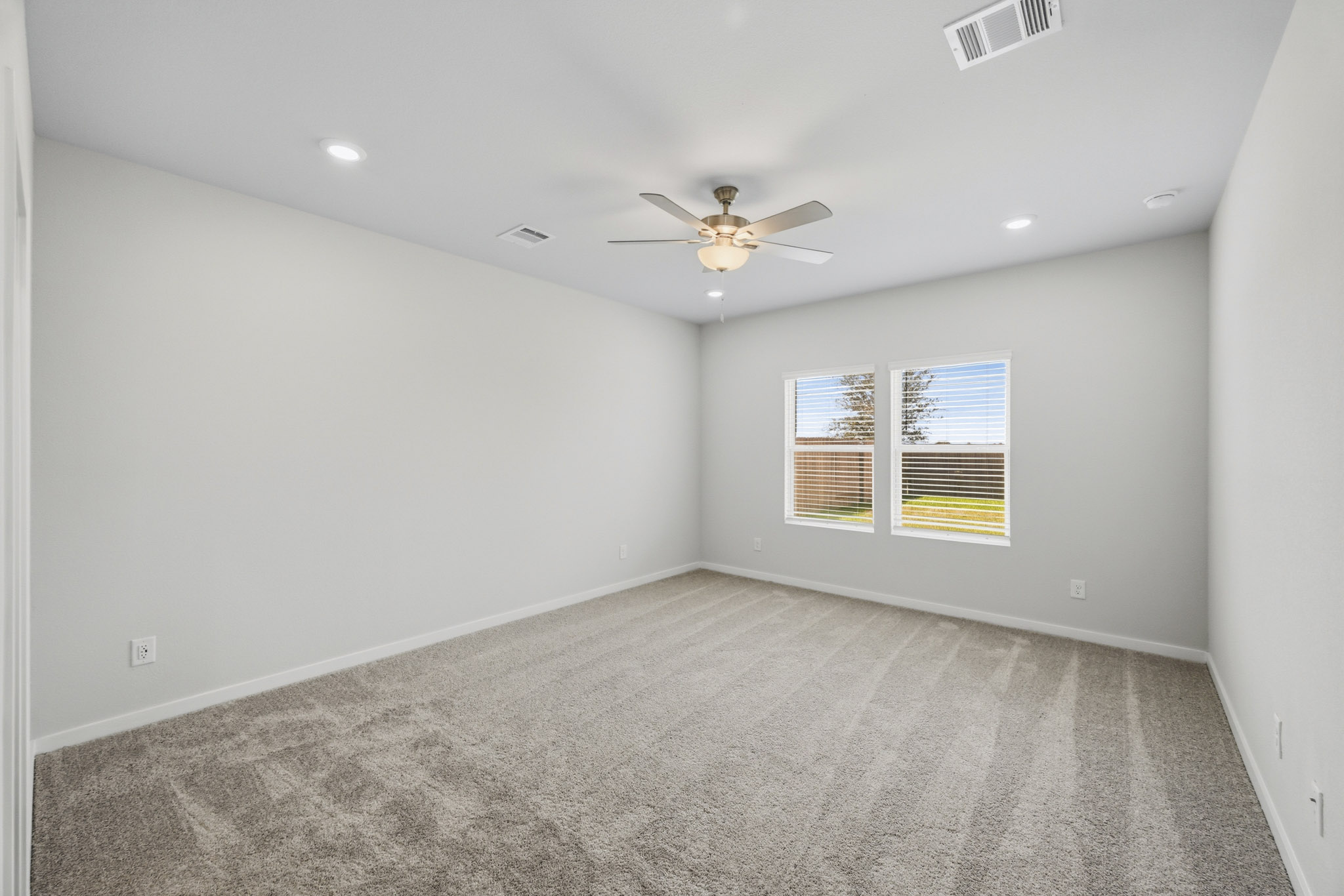 A room with a ceiling fan and a window.
