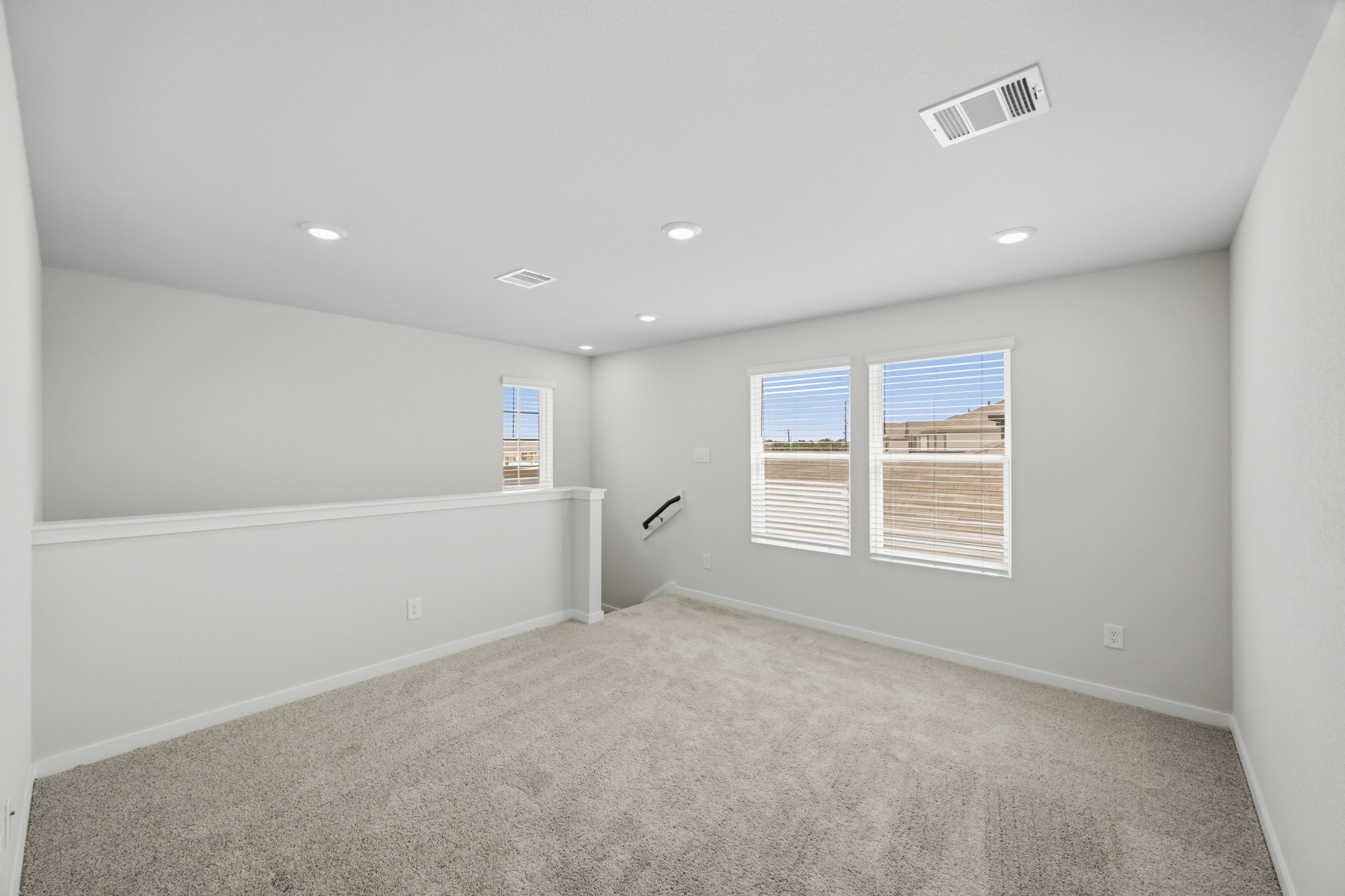 A room with a carpet and windows.