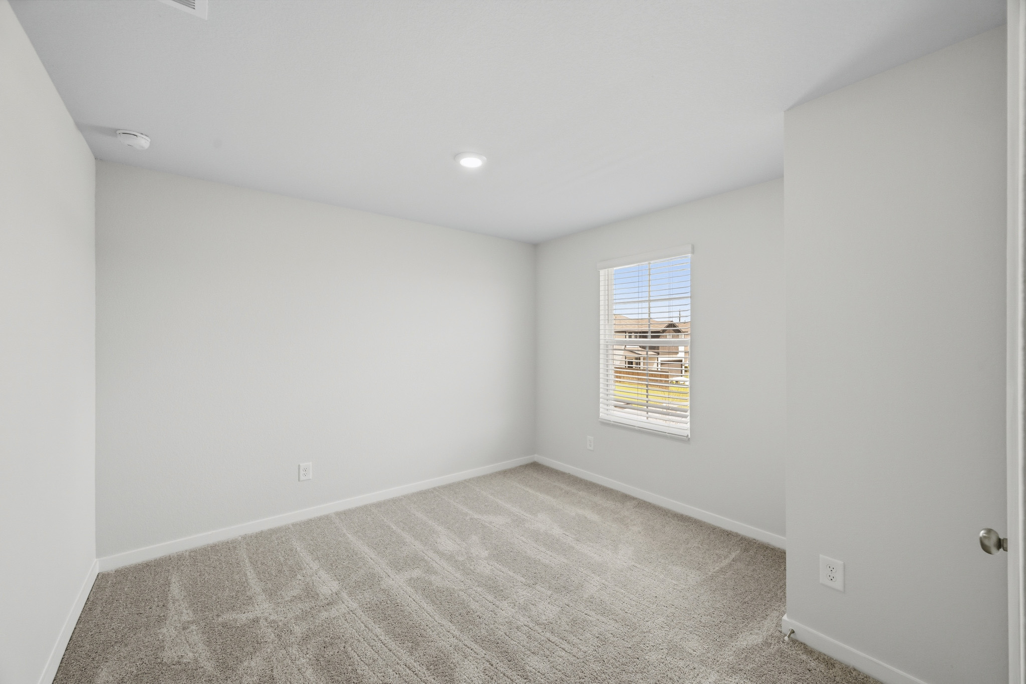 A room with a carpet and a door.