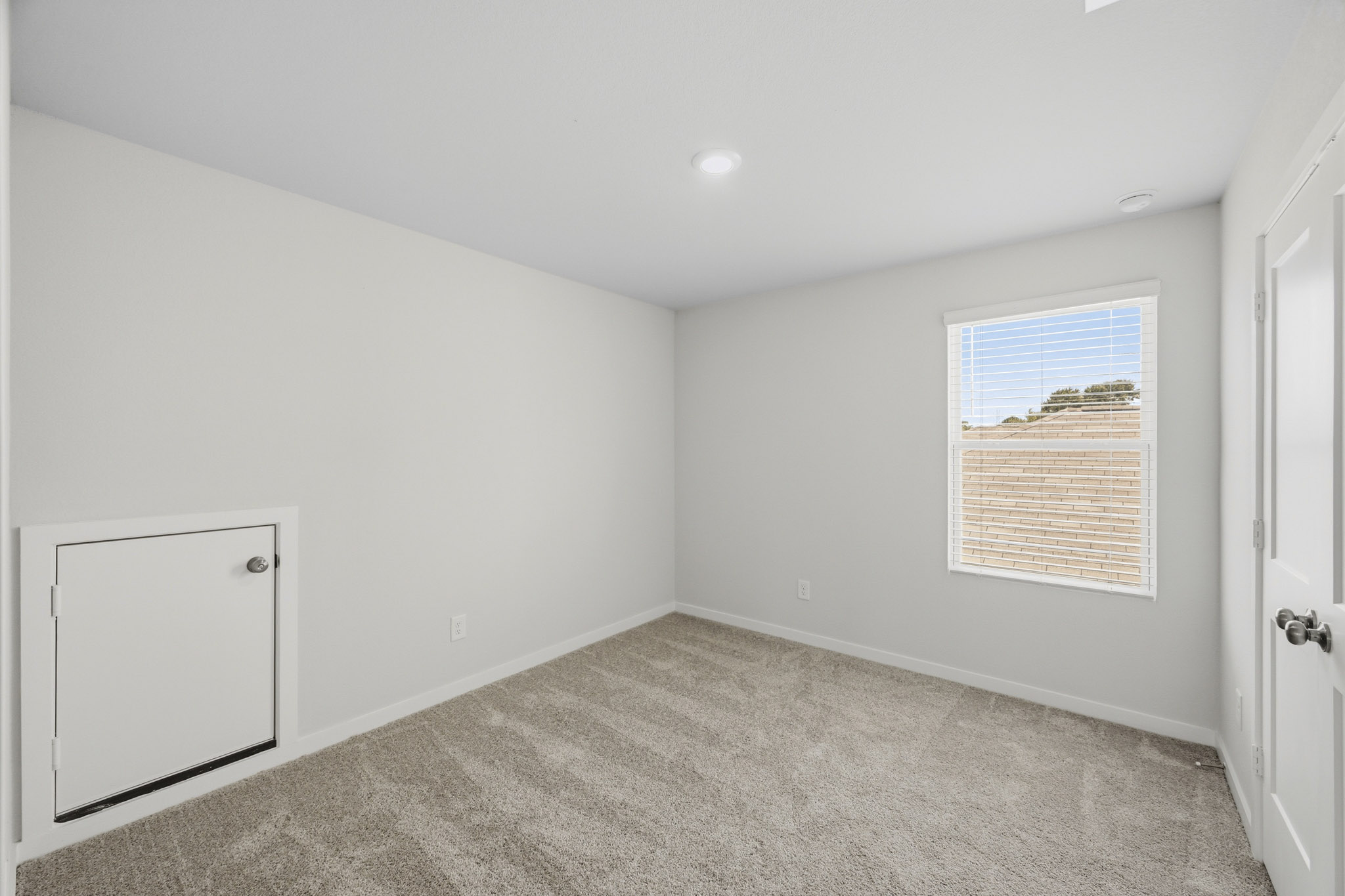 A room with a carpet and a window.