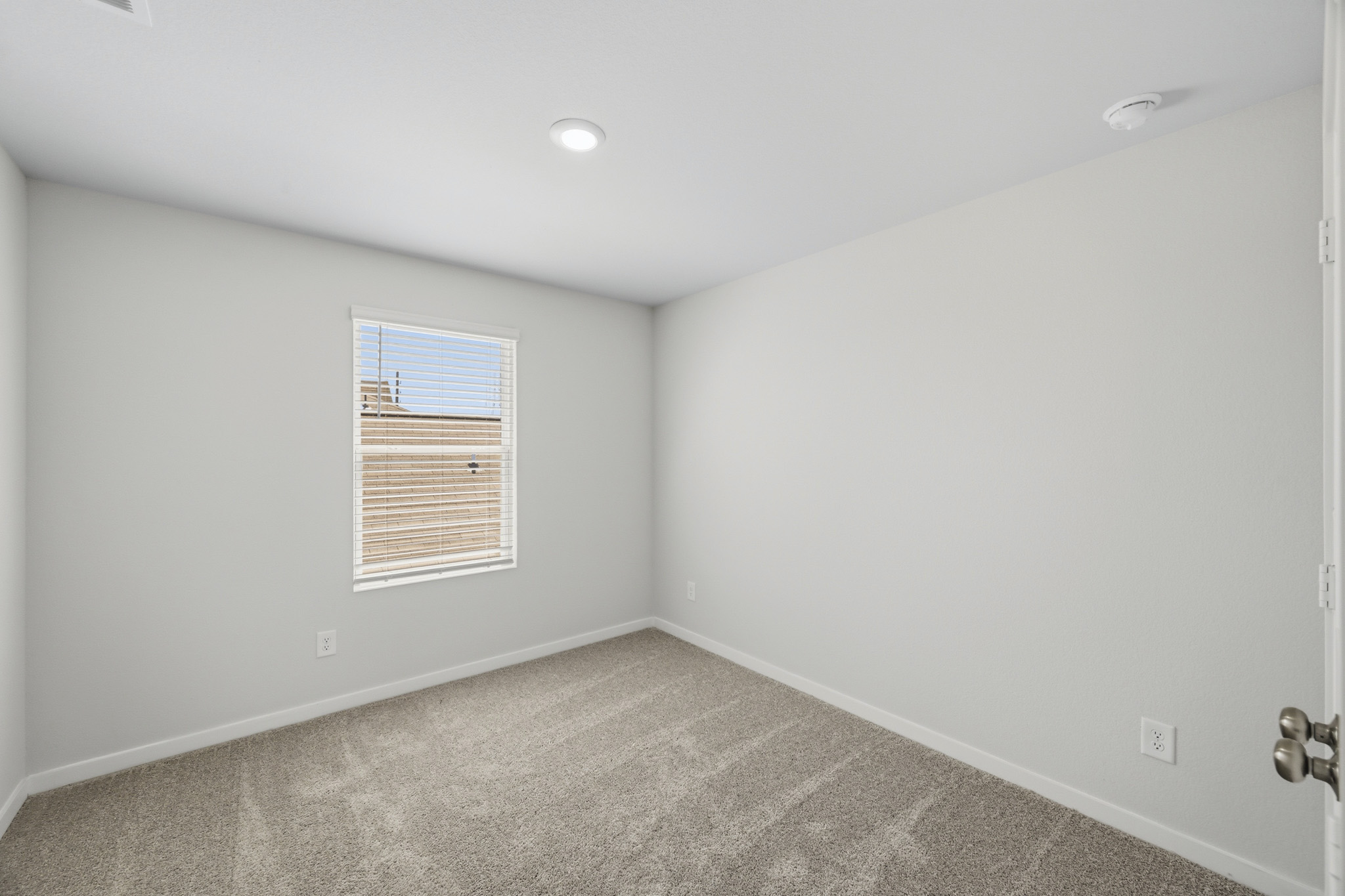A room with a carpet and a window.