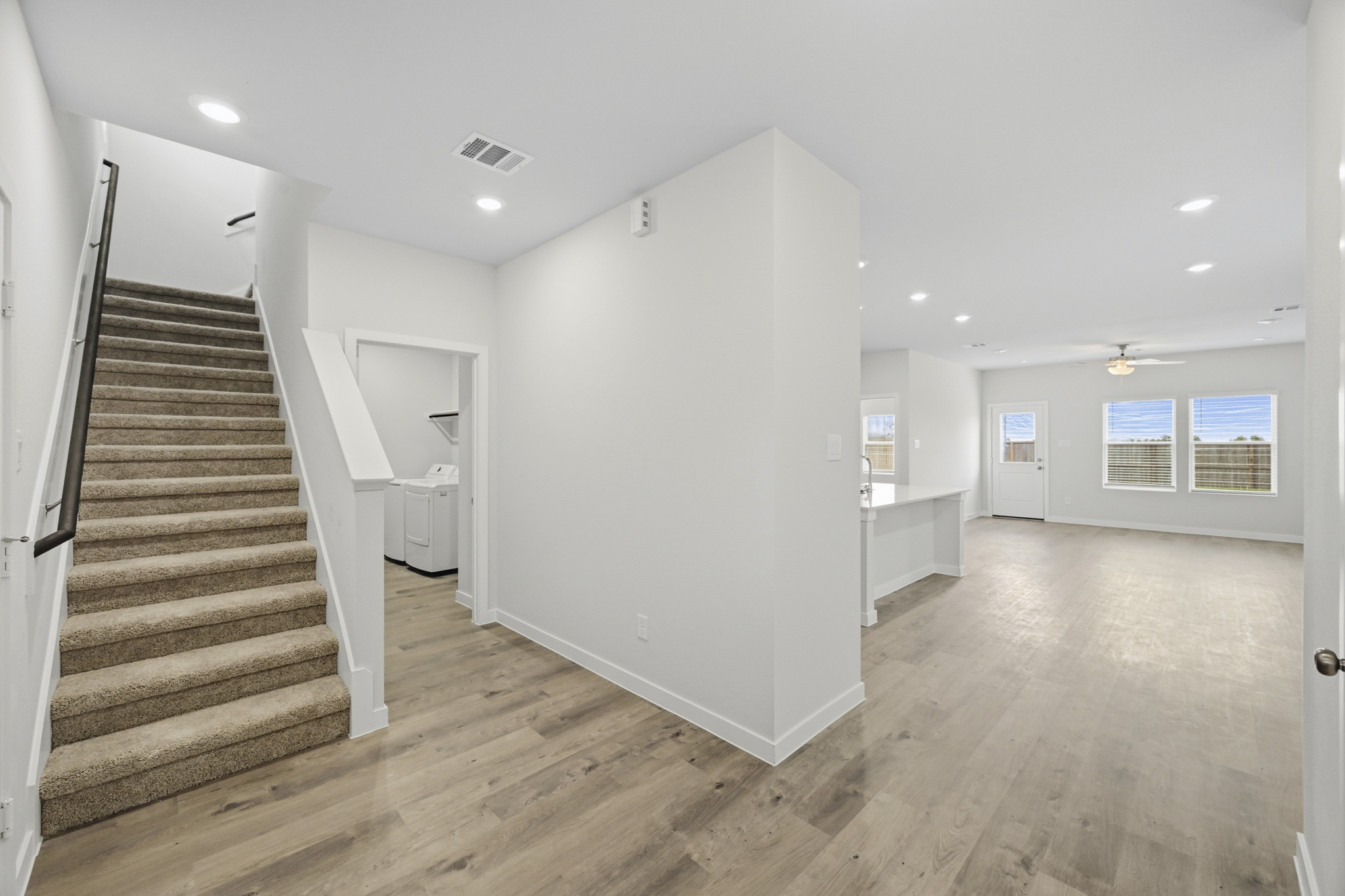 A large empty room with a staircase.